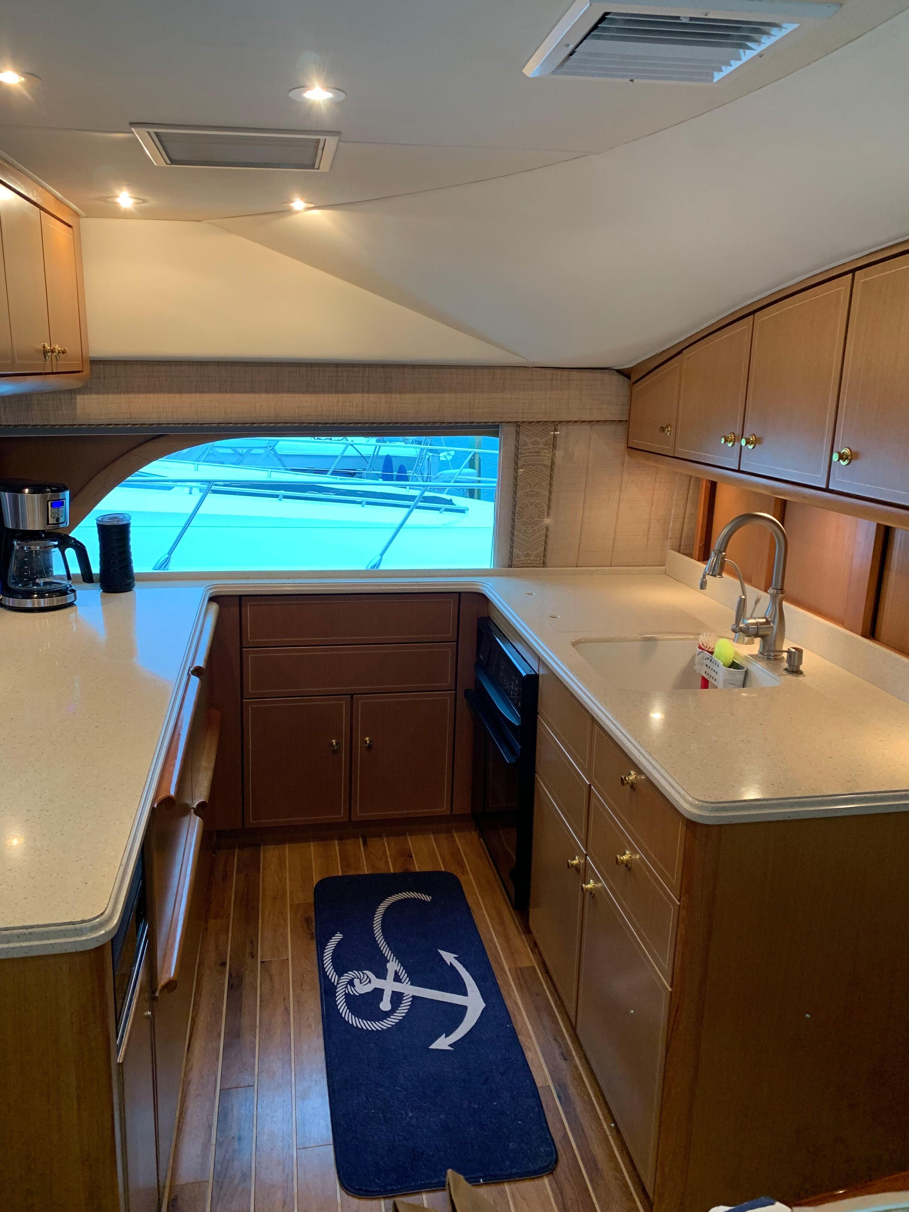 Luxurious kitchen interior of 2004 Ocean Yachts 57 Odyssey with wood cabinetry and modern appliances.