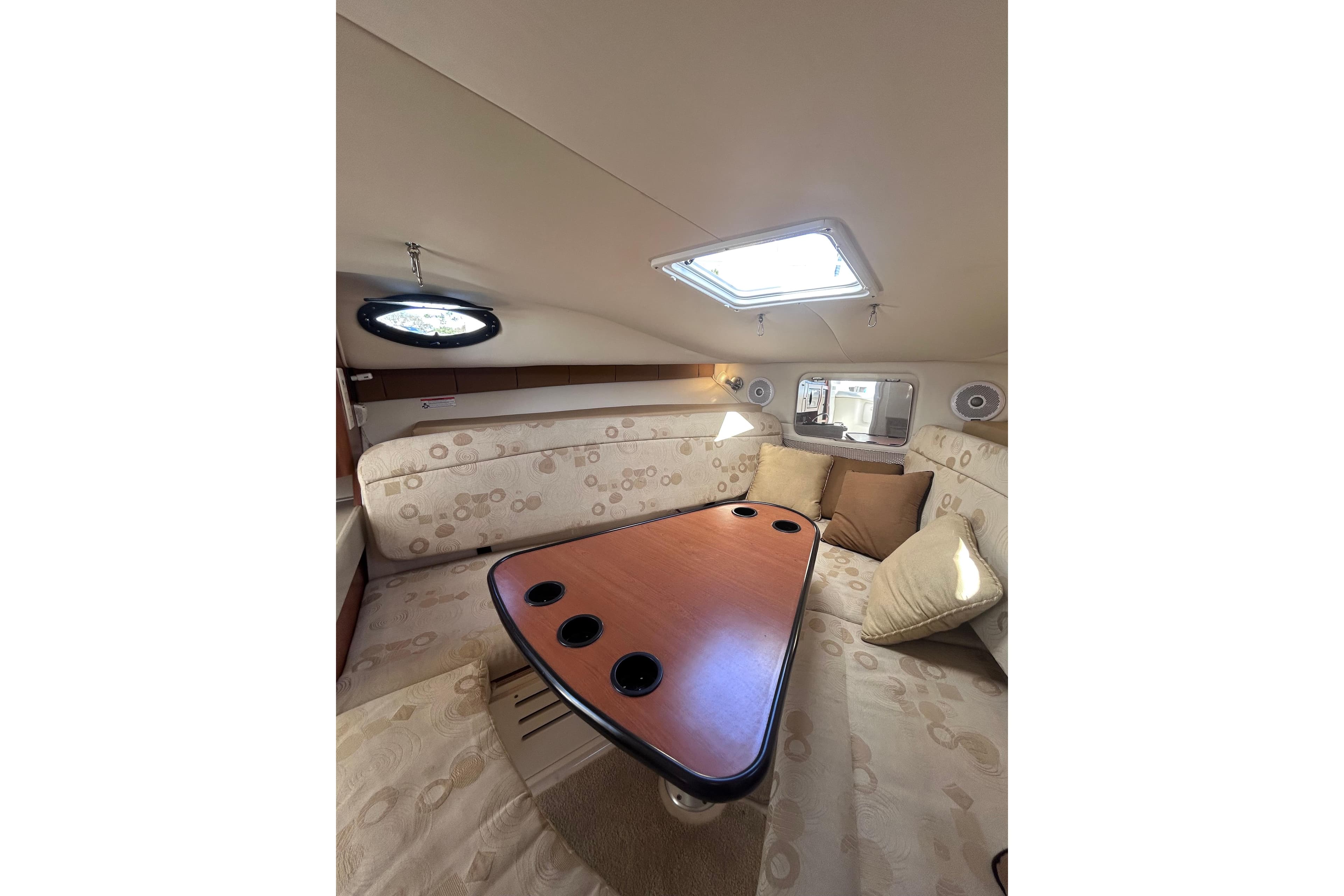 2006 Wellcraft 290 Coastal cabin interior with seating and table, featuring neutral tones.