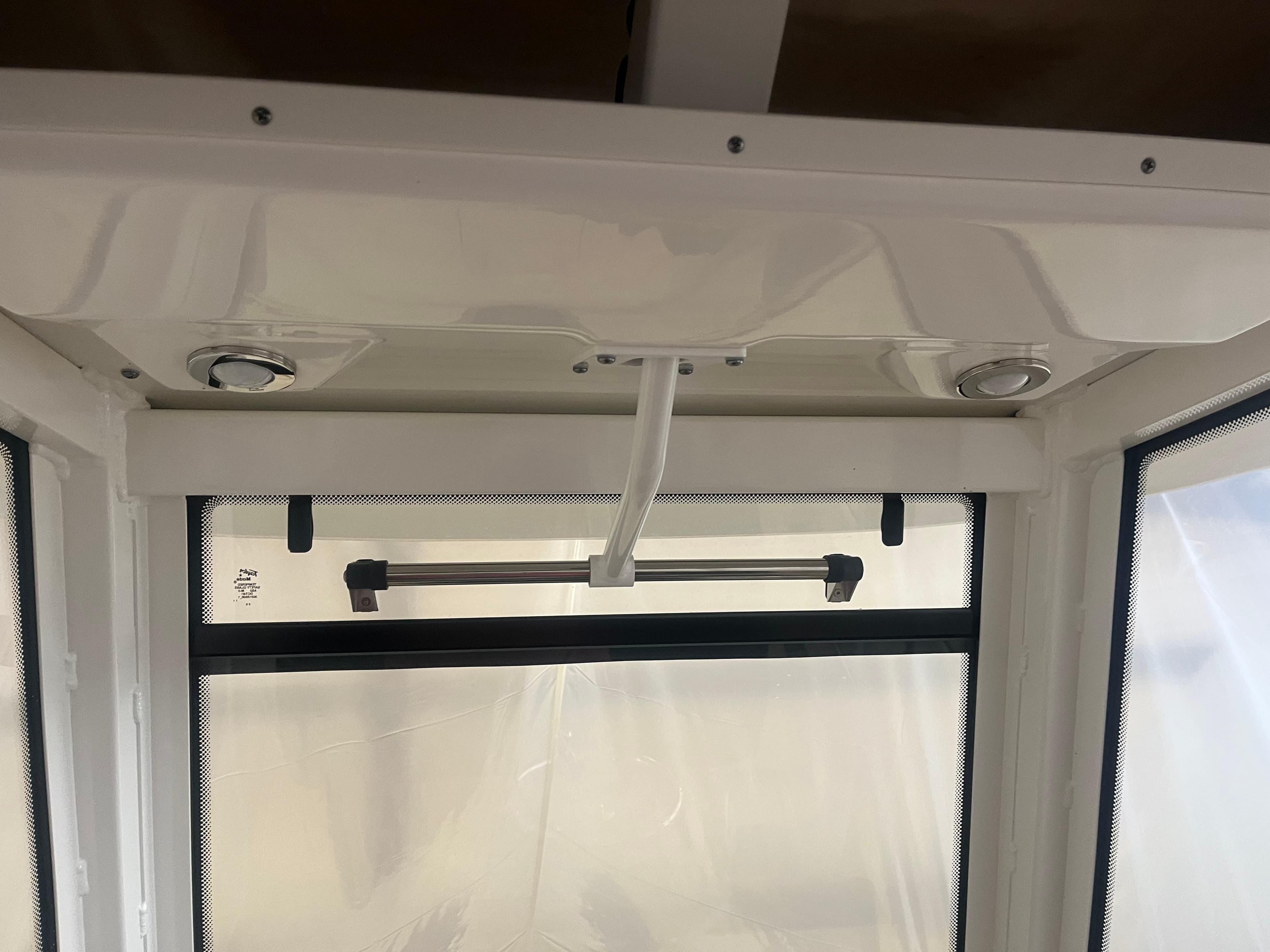 Interior view of 2021 Robalo R272 Center Console boat with window and ceiling details.