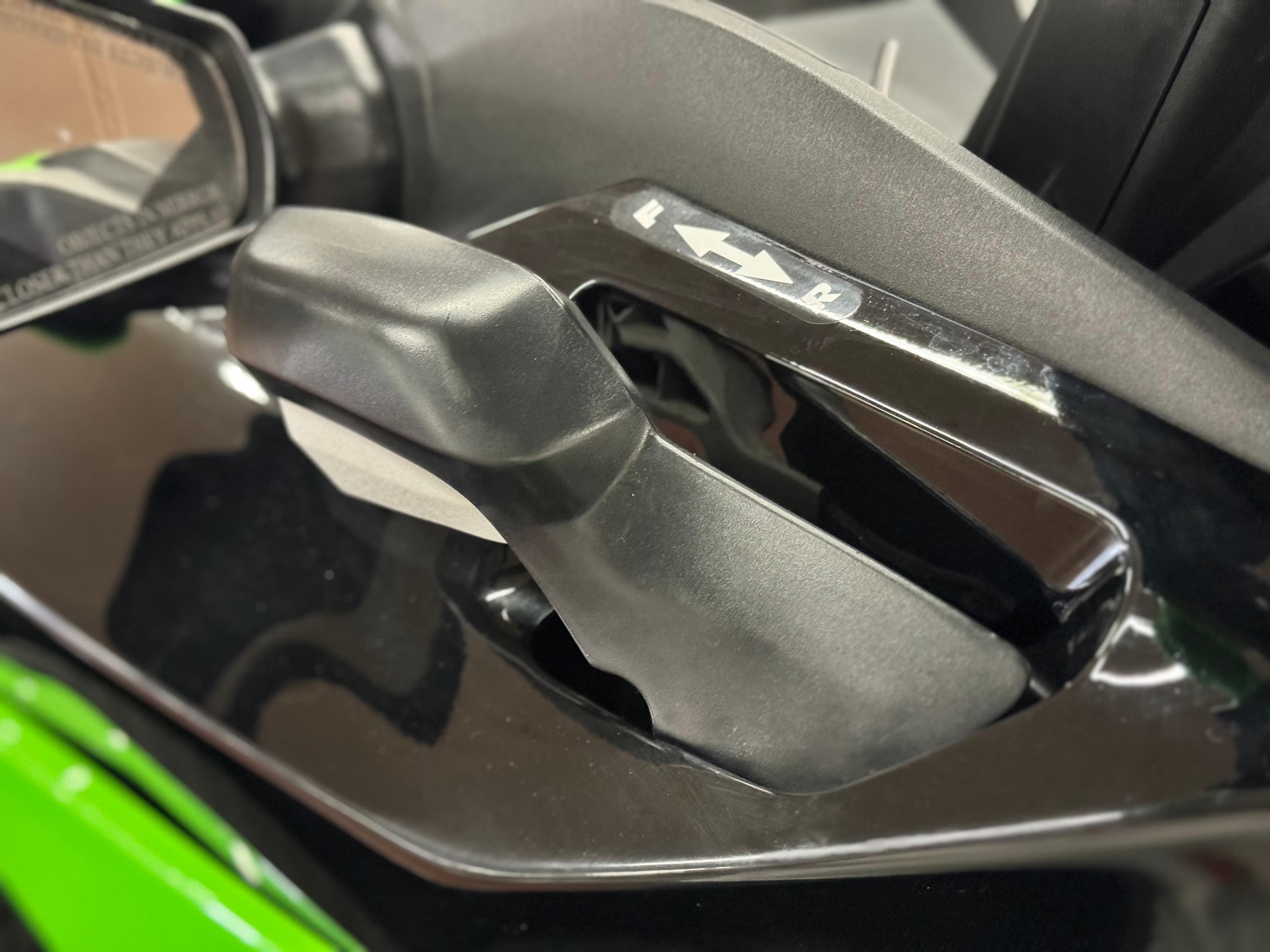 Close-up of 2023 Kawasaki Jetski STX 160X handlebar controls, featuring sleek black design.
