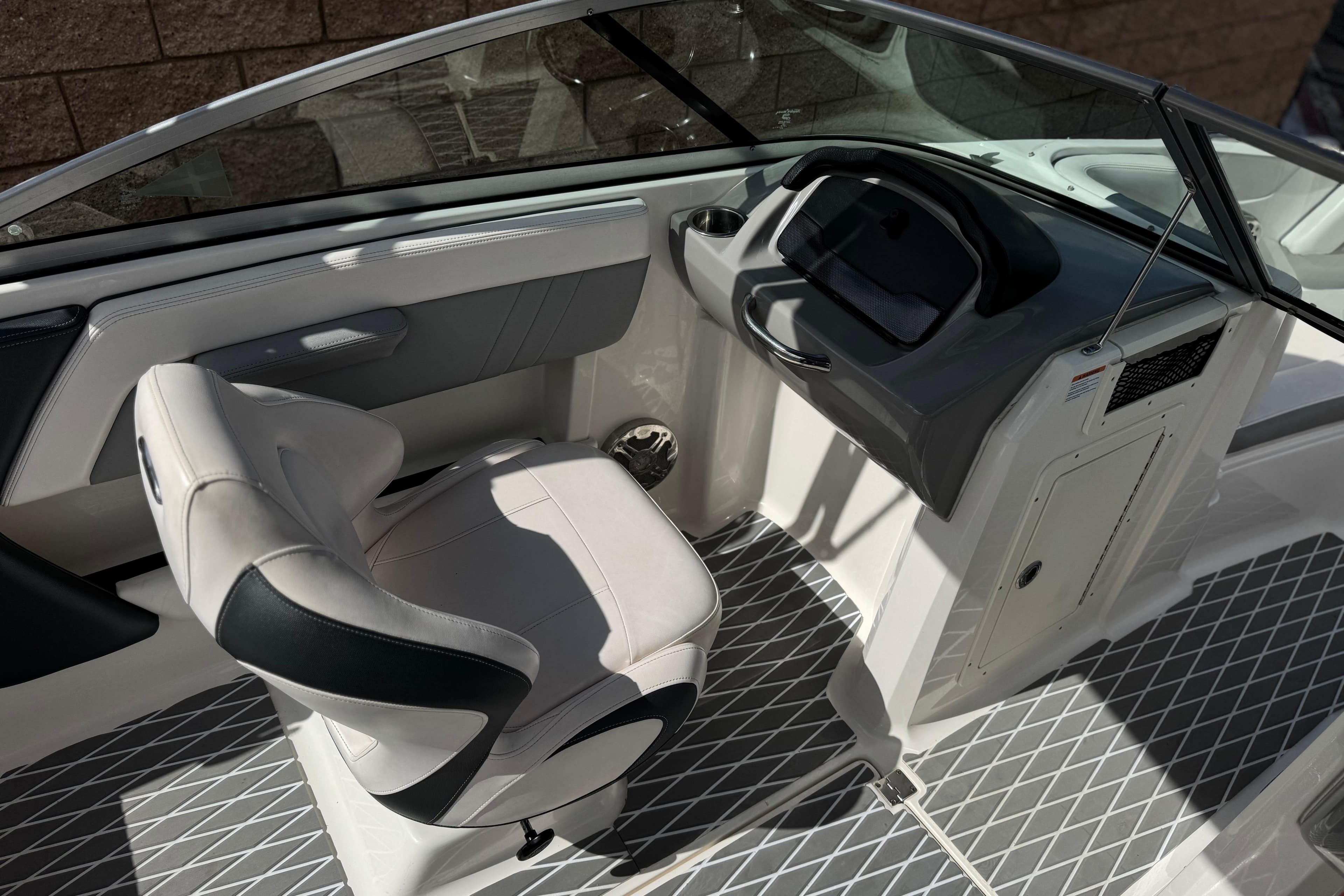 Interior of 2020 Chaparral 21 Surf boat, featuring sleek helm and comfortable seating.