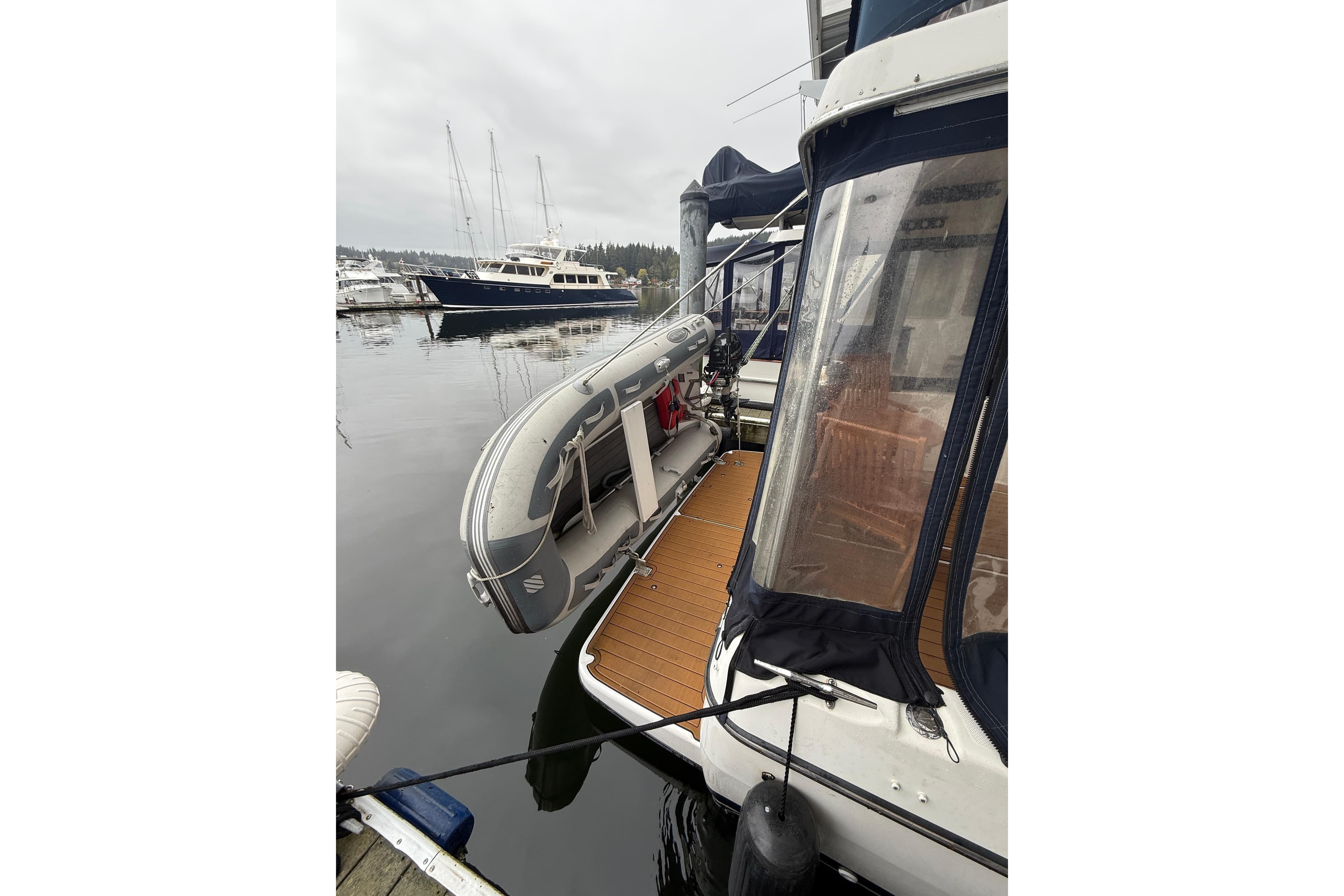 2001 Bayliner 3388 Command Bridge Motoryacht docked with inflatable dinghy attached.
