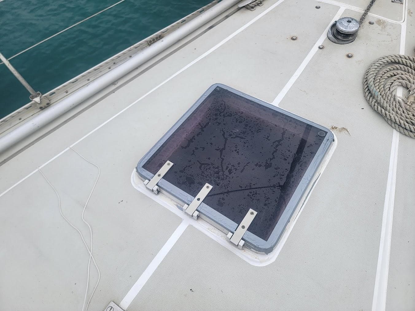 Deck of 1984 Moody 419 sailboat with hatch and coiled rope.