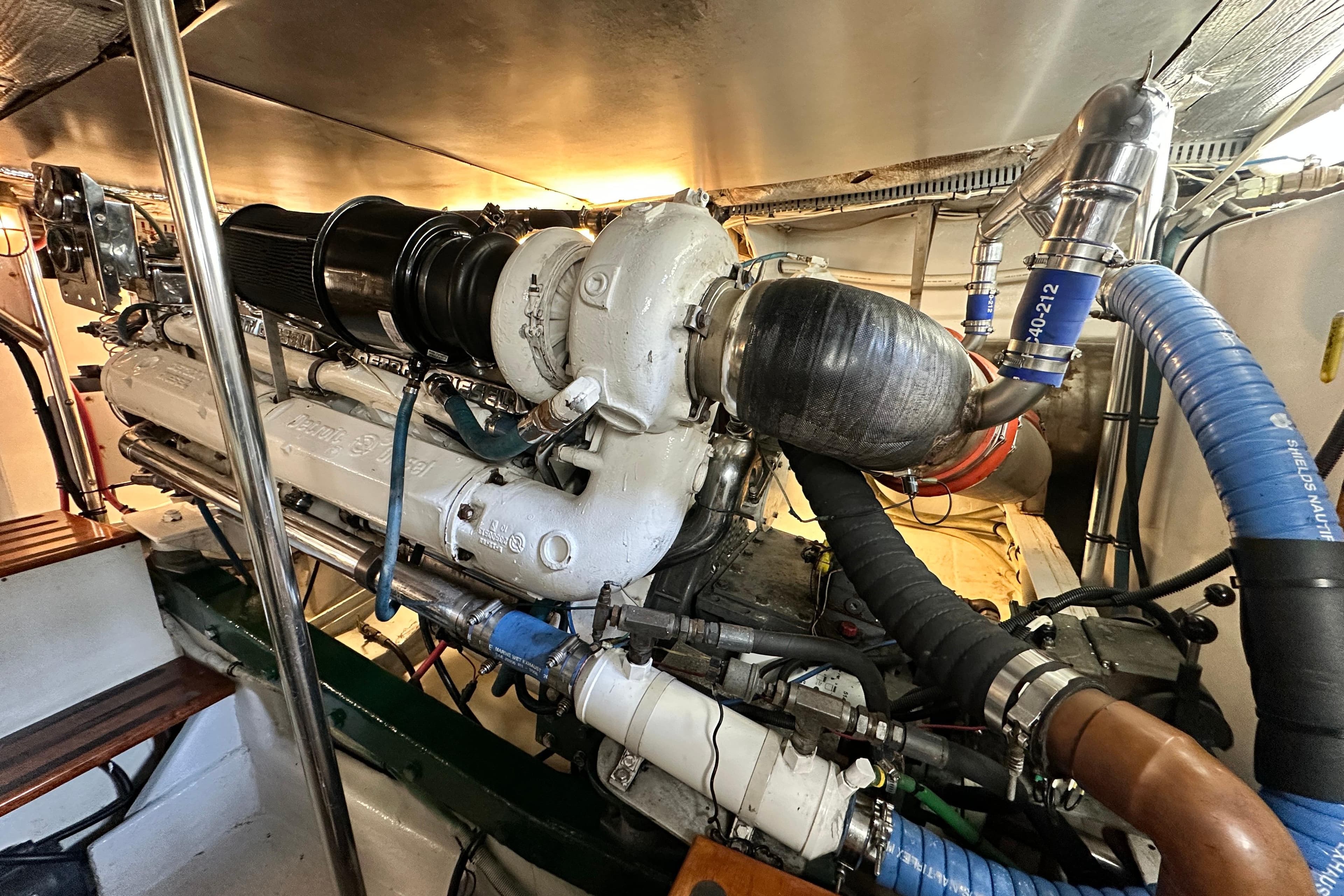 Engine room of a 1980 Bertram 58 Convertible yacht, showcasing detailed machinery.