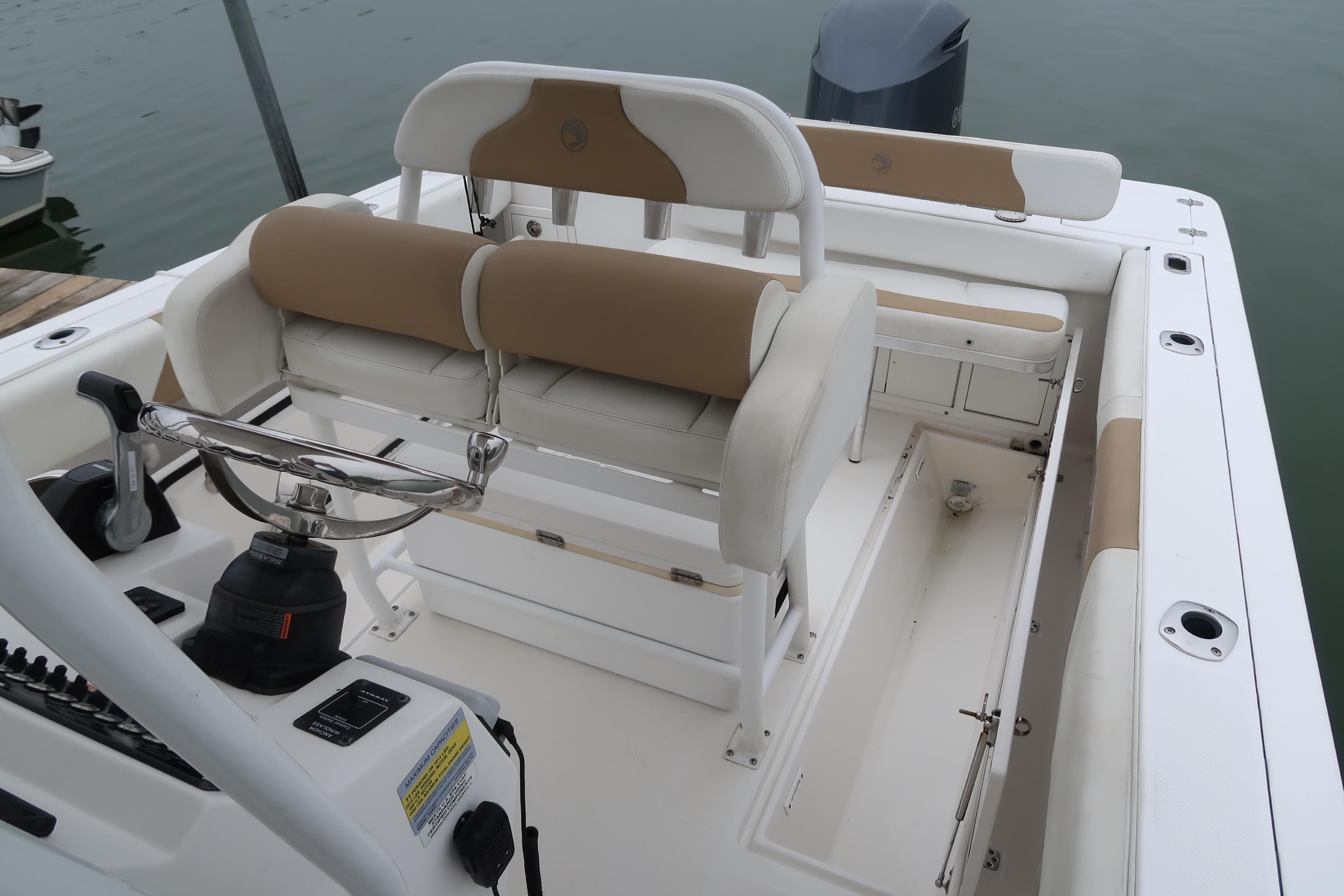2017 Edgewater 245CC boat interior with helm, seating, and storage compartments.