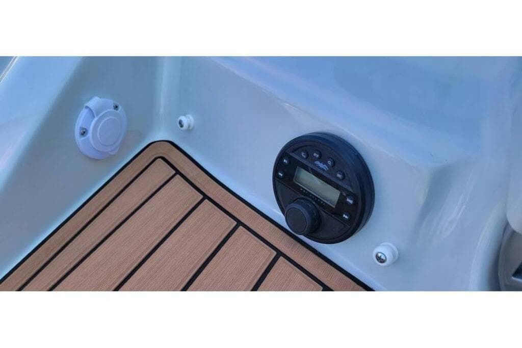 2024 Crownline Eclipse E235 boat dashboard with audio controls and teak-style flooring.