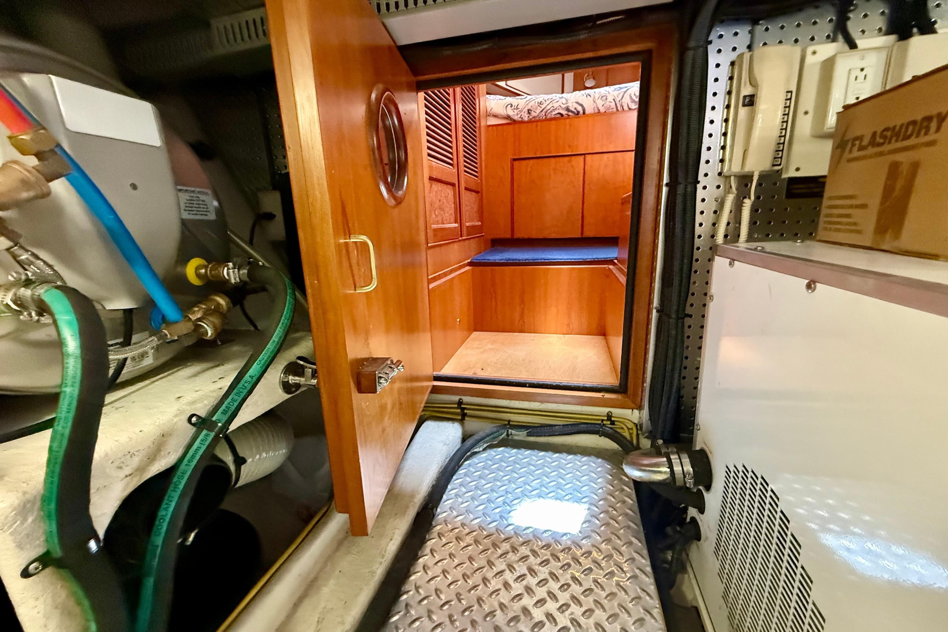 Engine room of a 2002 President Aft Cabin Trawler with wooden door and equipment.