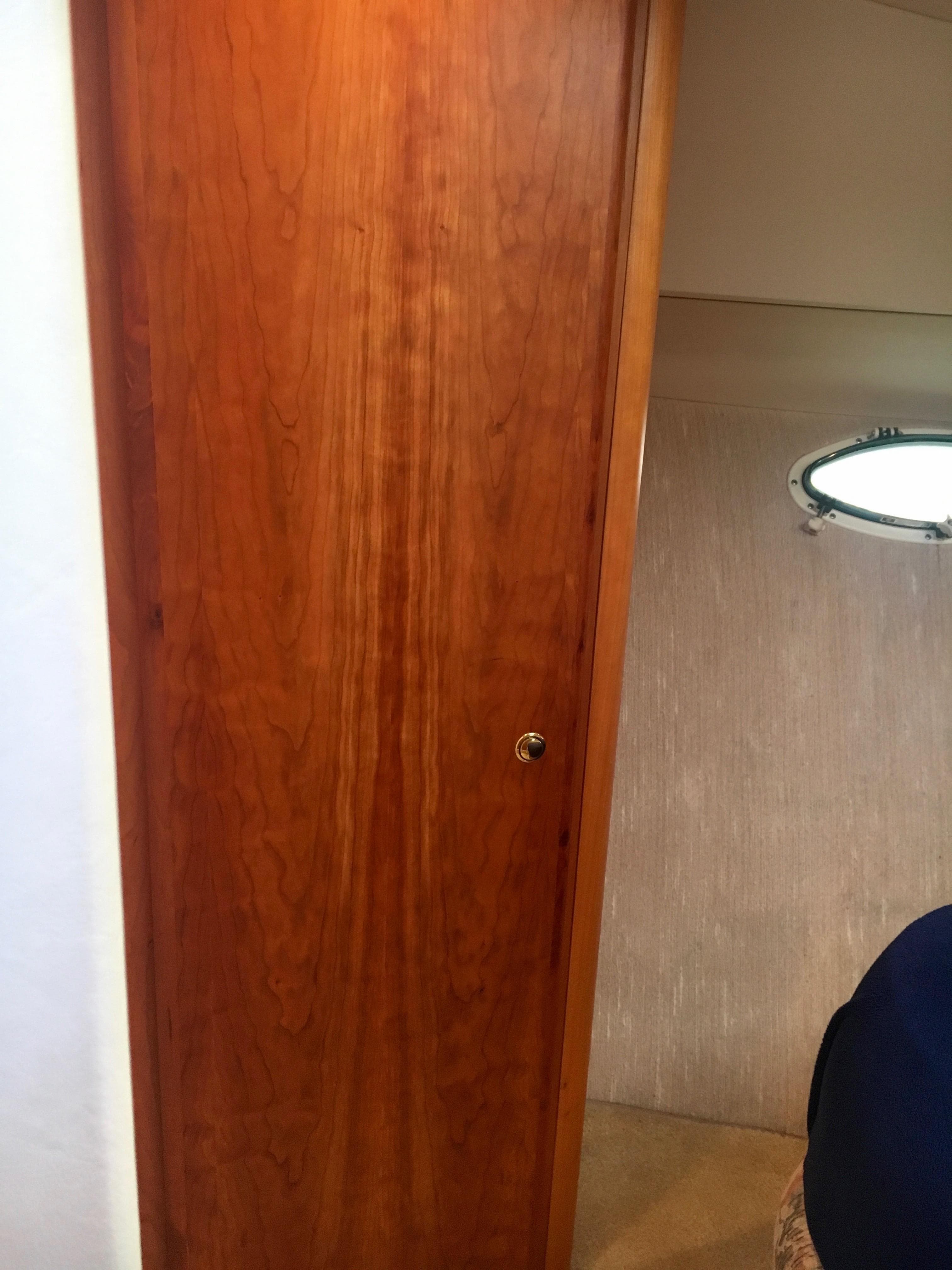 Interior of 1999 Silverton 351 Sedan with wooden door and porthole.
