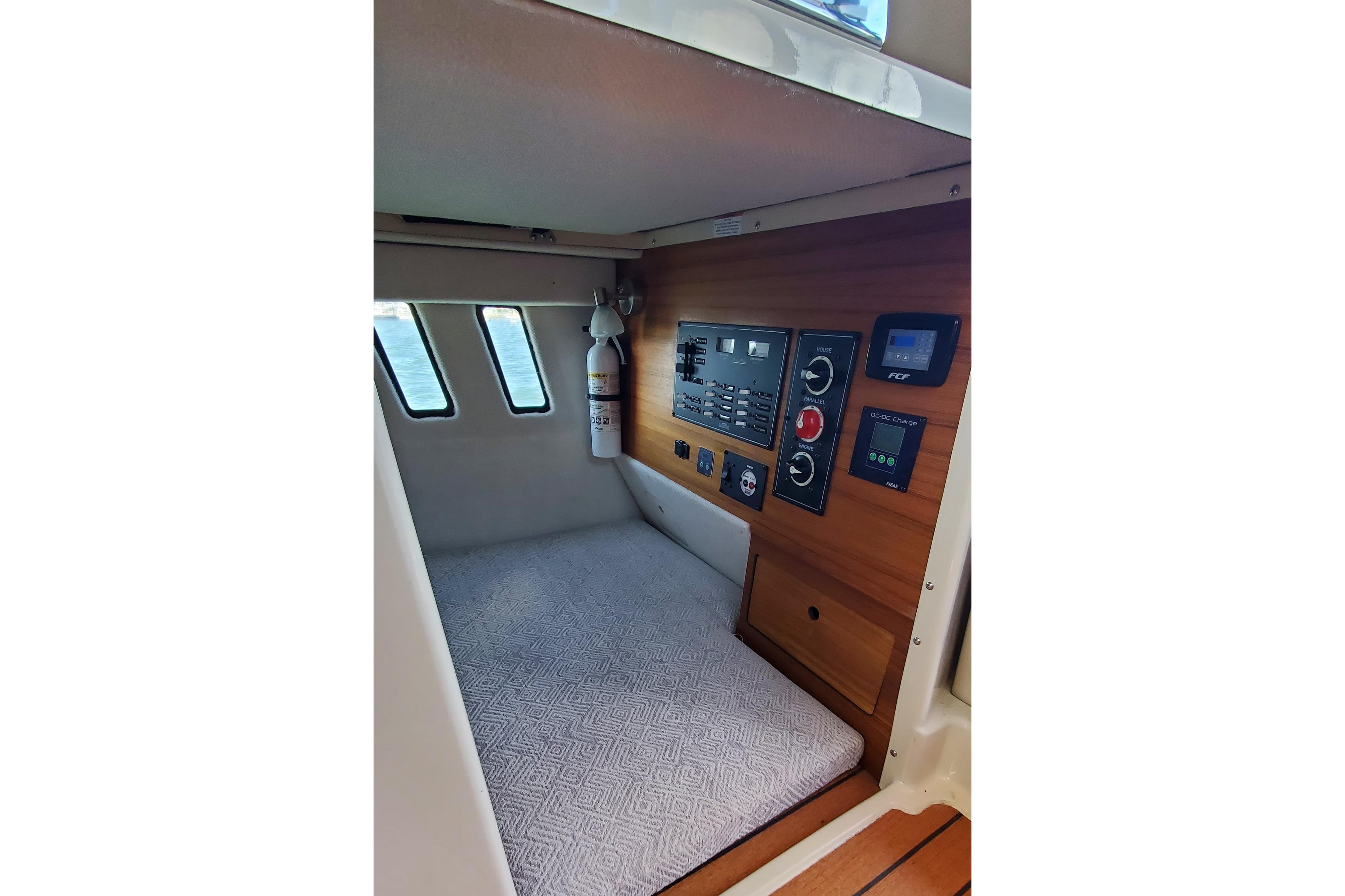 2024 Ranger Tugs R-27 cabin interior with control panel and fire extinguisher.