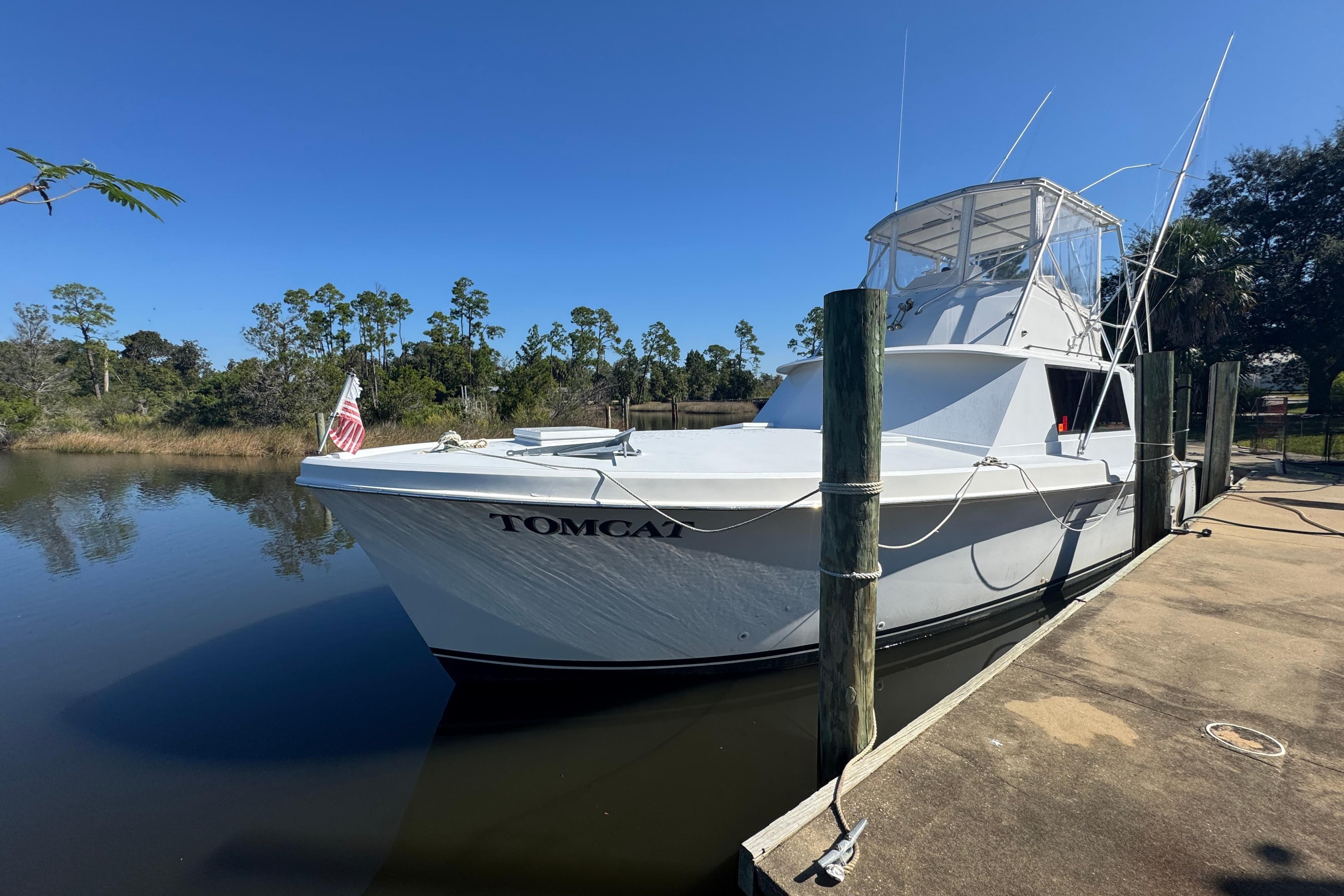 1965 Hatteras 41 Convertible boat docked on a sunny day, named "Tomcat."