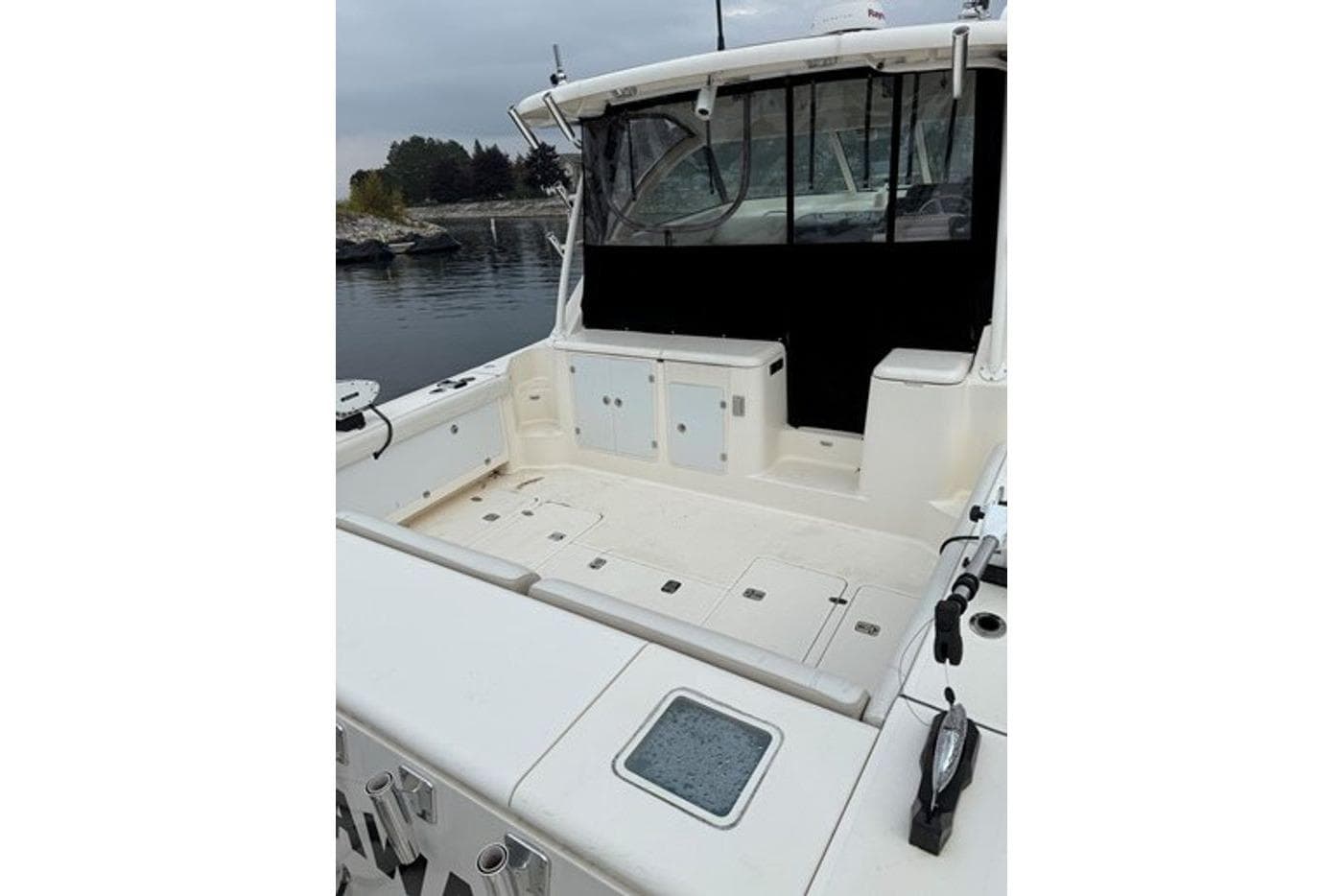 2009 Pursuit OS 375 Offshore boat with spacious deck and seating, docked by calm waters.