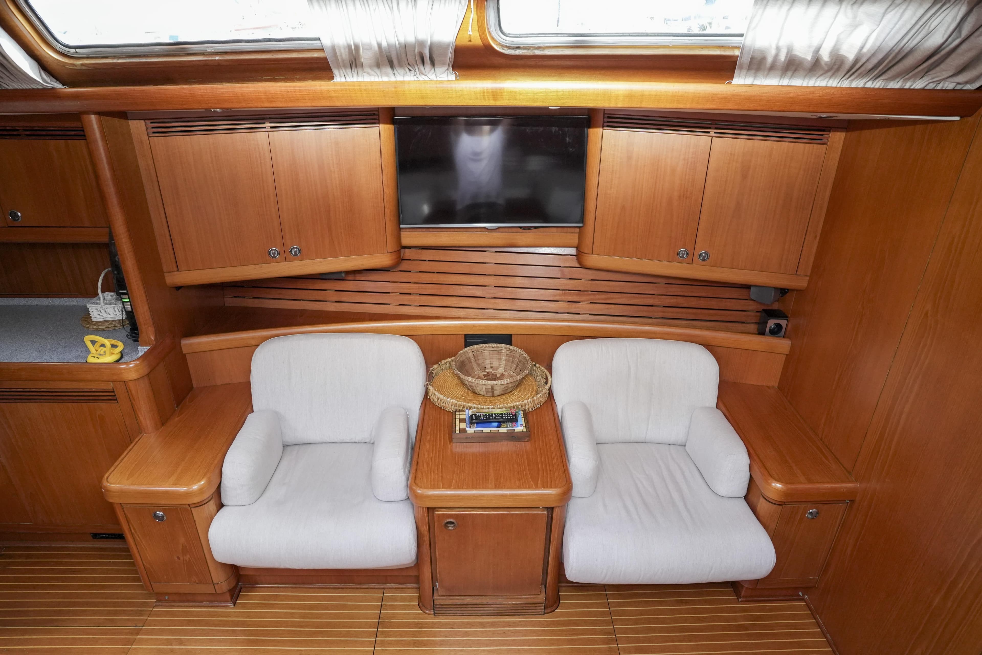 Luxurious 1998 Nautor Swan 60 yacht interior with wooden cabinetry and comfortable seating.