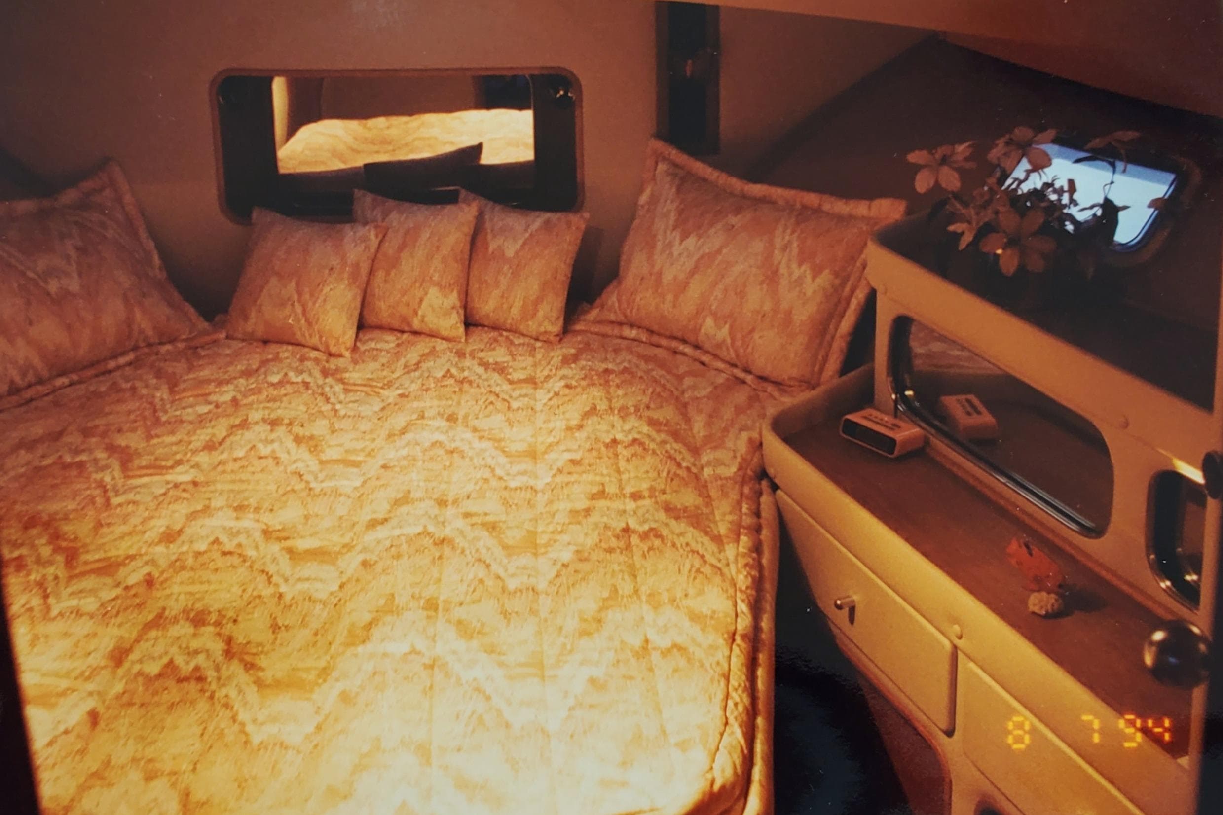 Cozy cabin interior of 1989 Chris-Craft Catalina 381 with plush bedding and elegant decor.