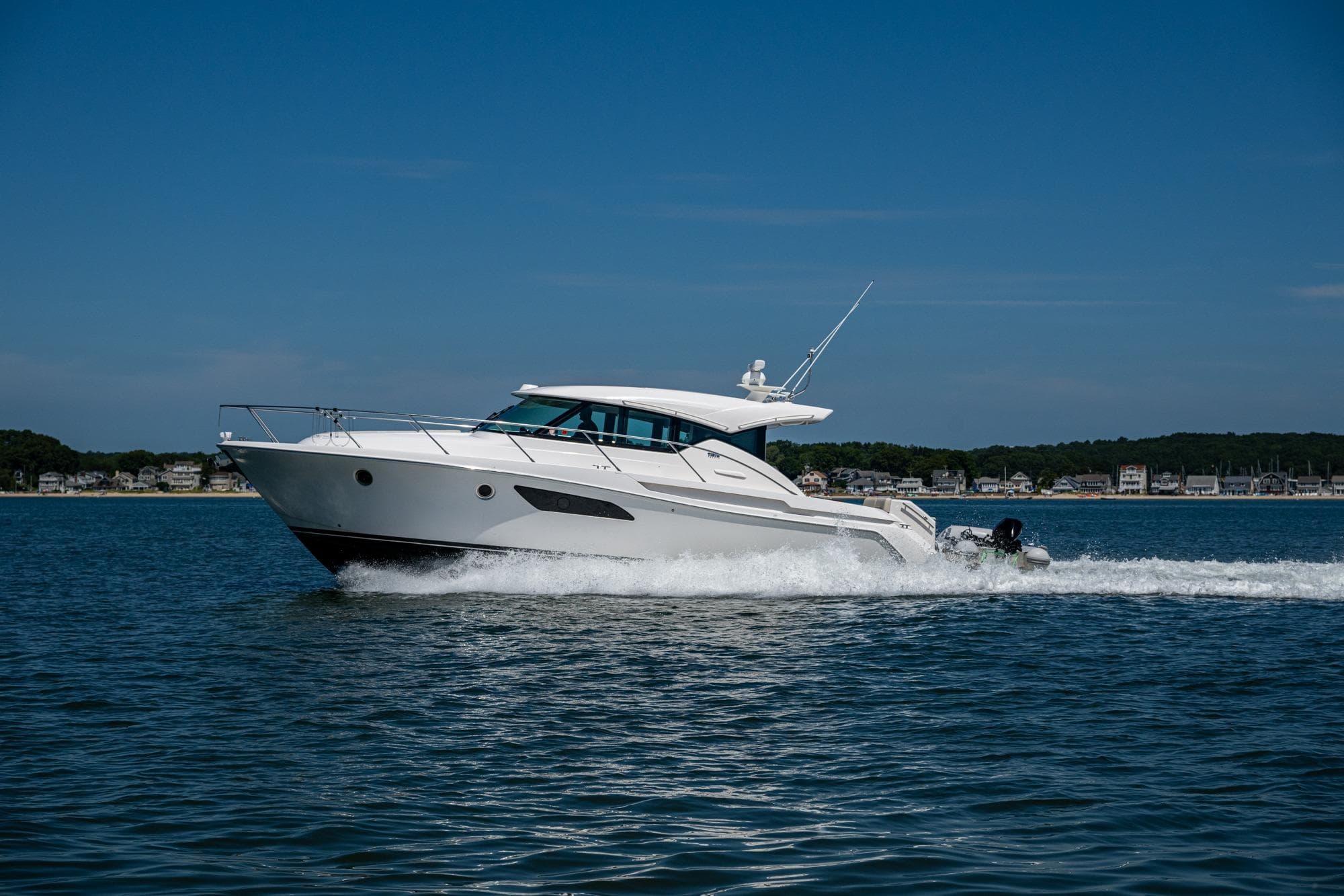 2020 Tiara Yachts C44 Coupe cruising on open water under clear blue sky.