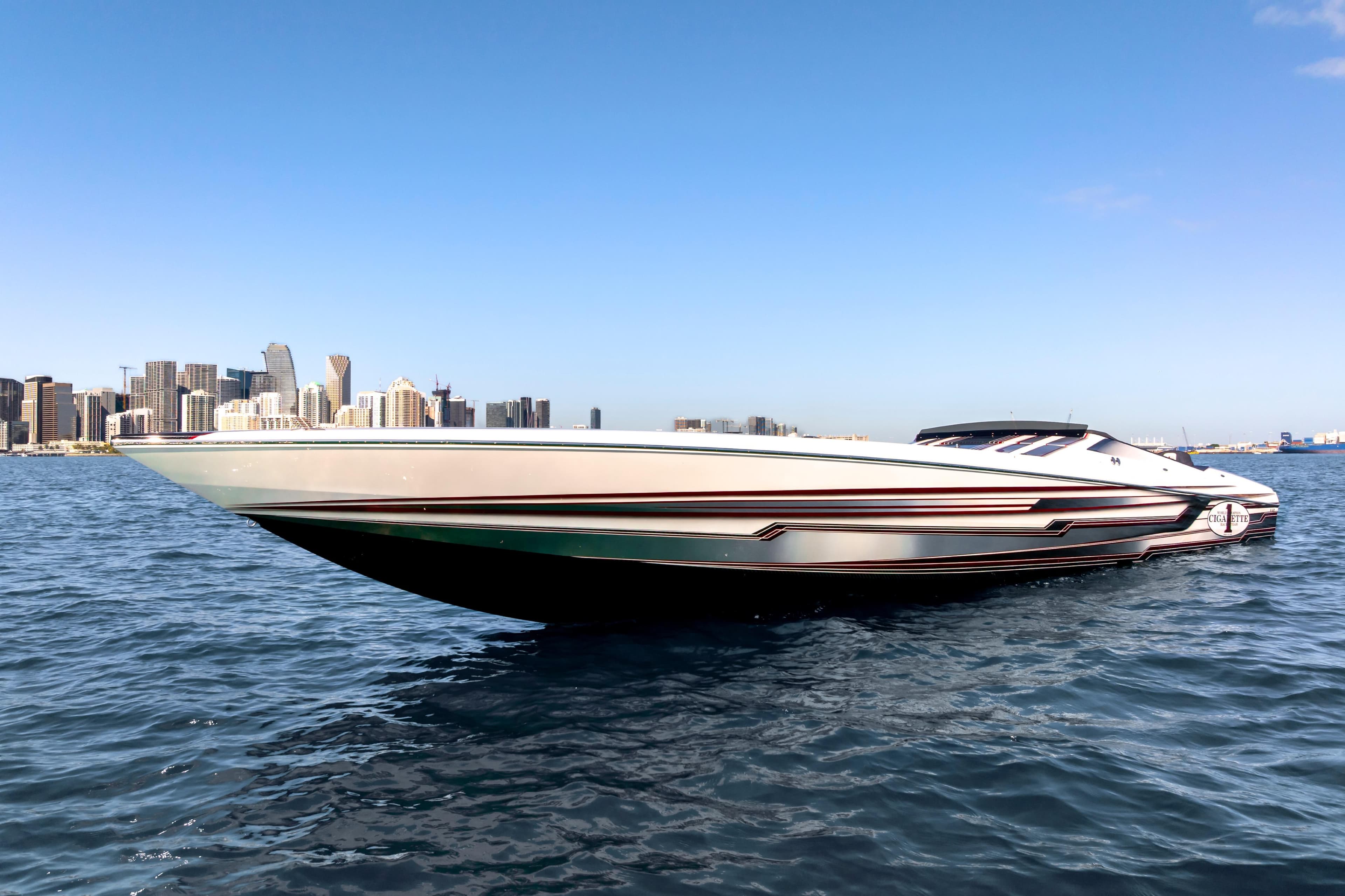 2020 Cigarette 515 speedboat on water with city skyline in background.