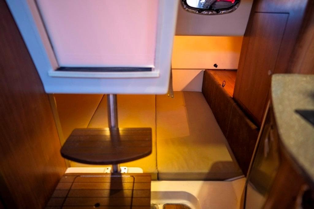 2014 Boston Whaler 315 Conquest cabin interior with wooden steps and cozy sleeping area.