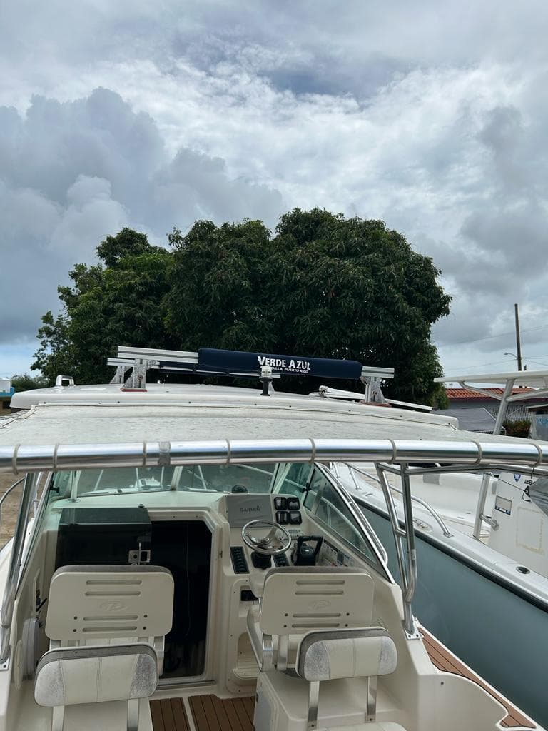 2012 Pursuit 255 boat with dual seats, docked under cloudy skies.