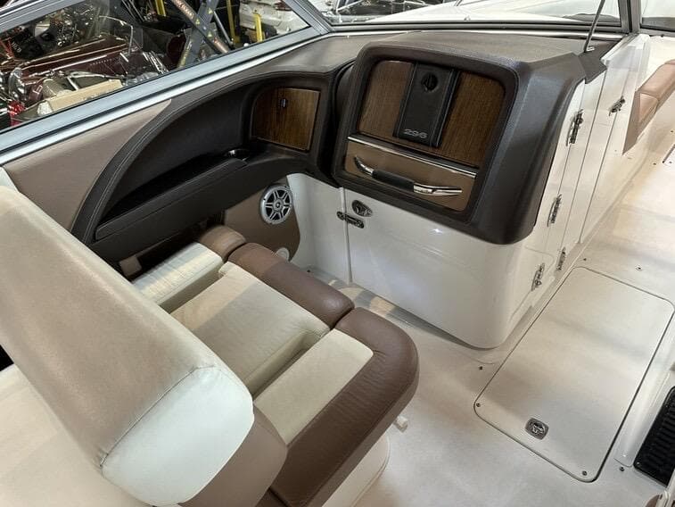 Interior of 2011 Cobalt 296 boat with beige and brown seating, wood accents, and storage compartments.