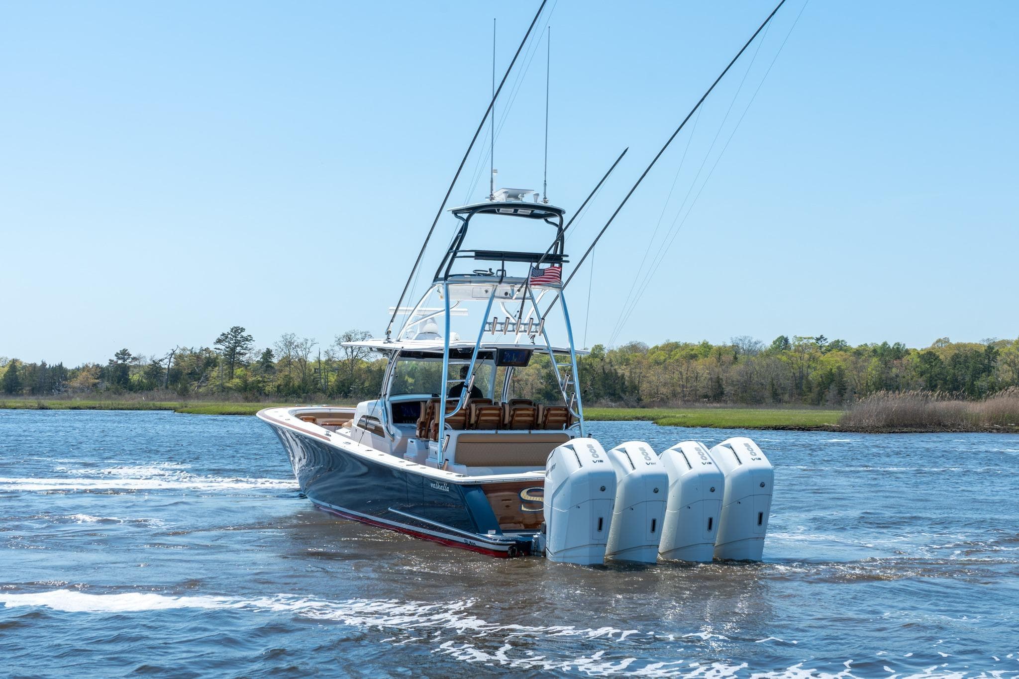 2023 Valhalla Boatworks V-46 cruising on a serene waterway with four engines.