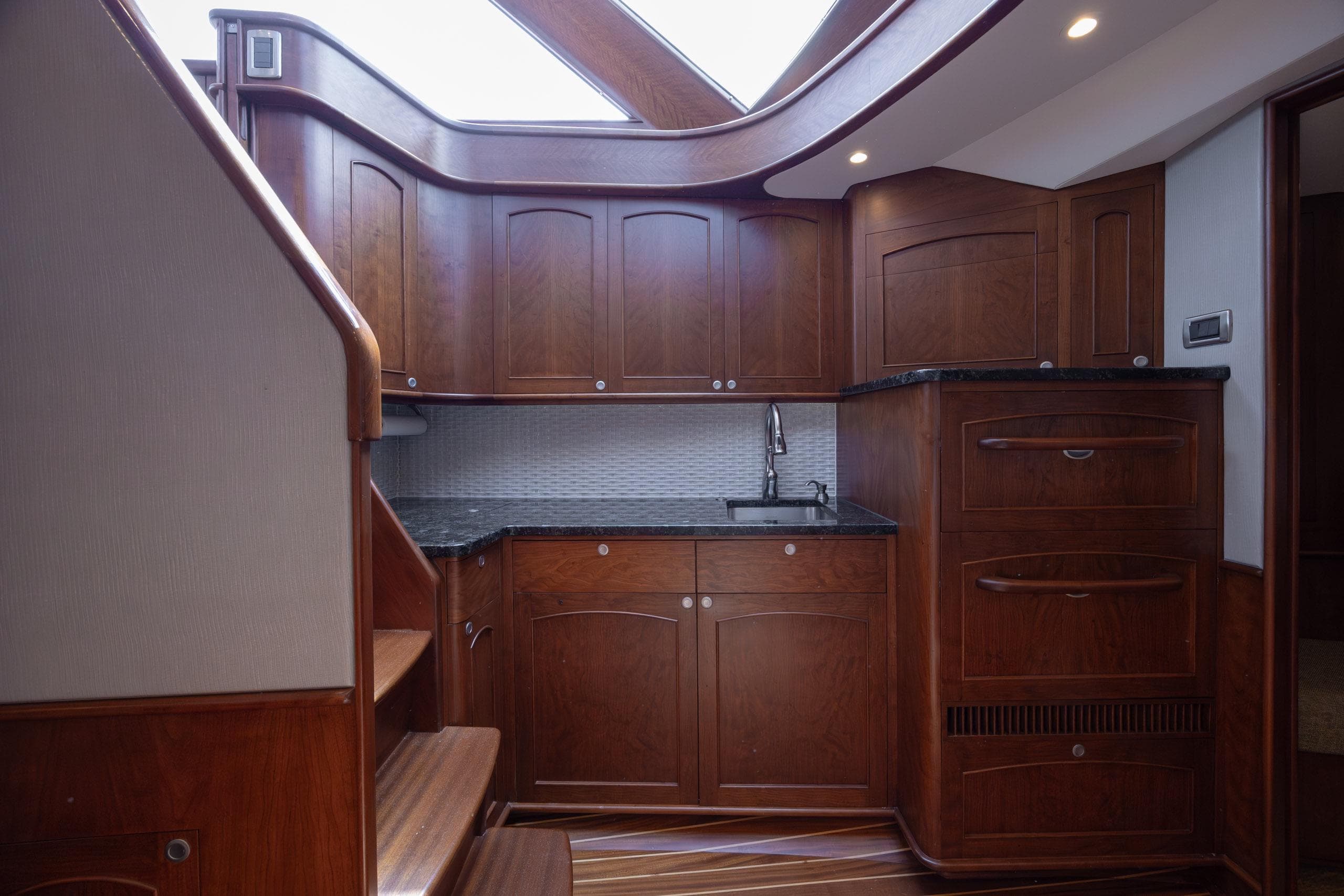 2015 Jarrett Bay Hardtop Express Sportfish interior with wooden cabinetry and modern fixtures.
