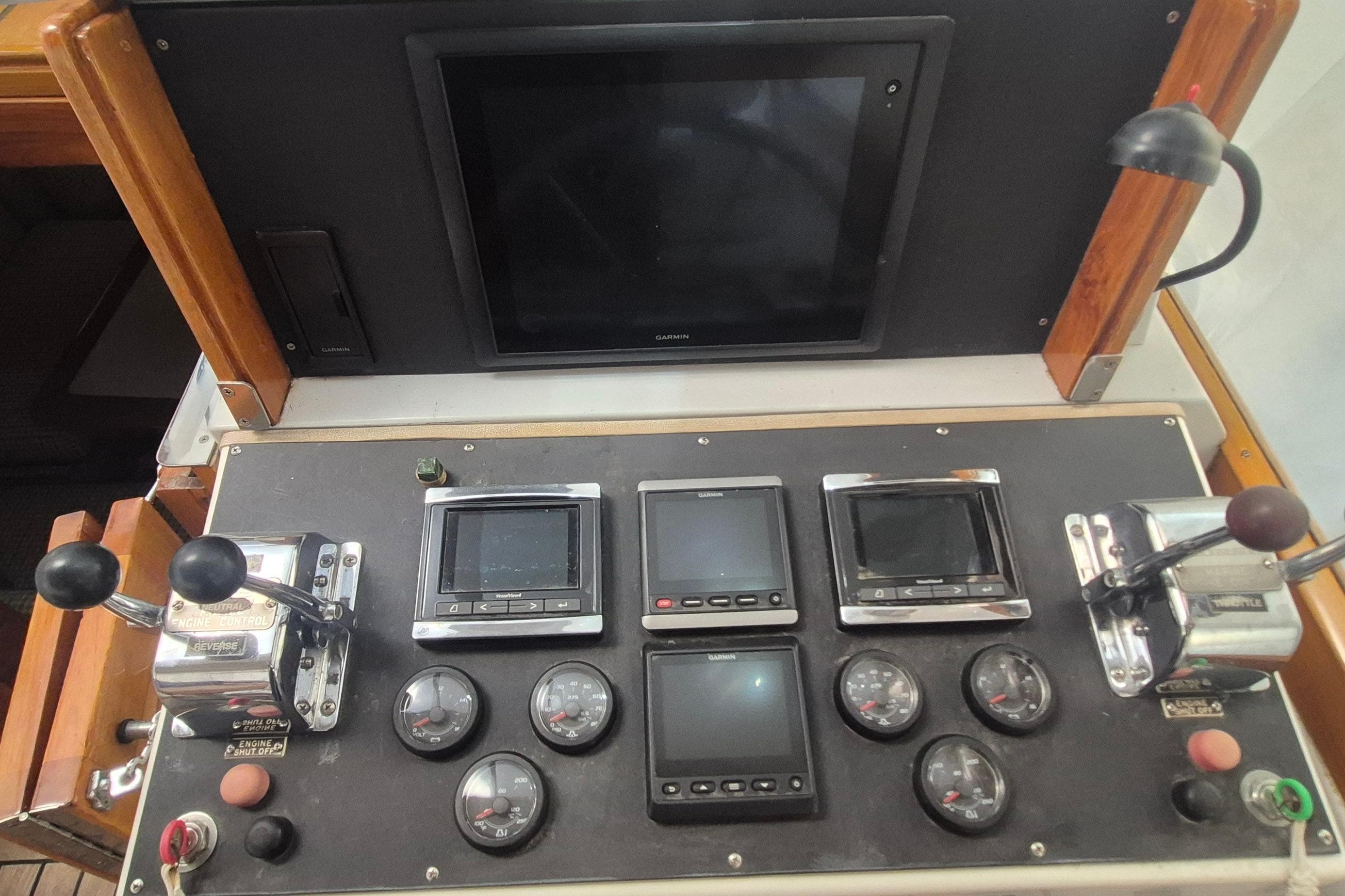 Control panel of a 1990 Little Harbor Express boat with gauges and screens.