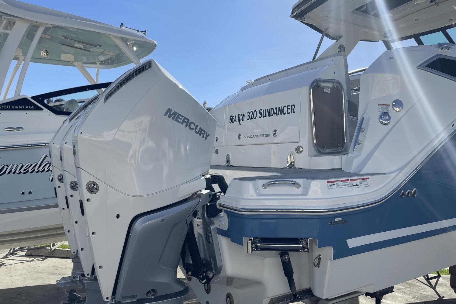 2024 Sea Ray Sundancer 320 Outboard with Mercury engines, docked under clear blue sky.