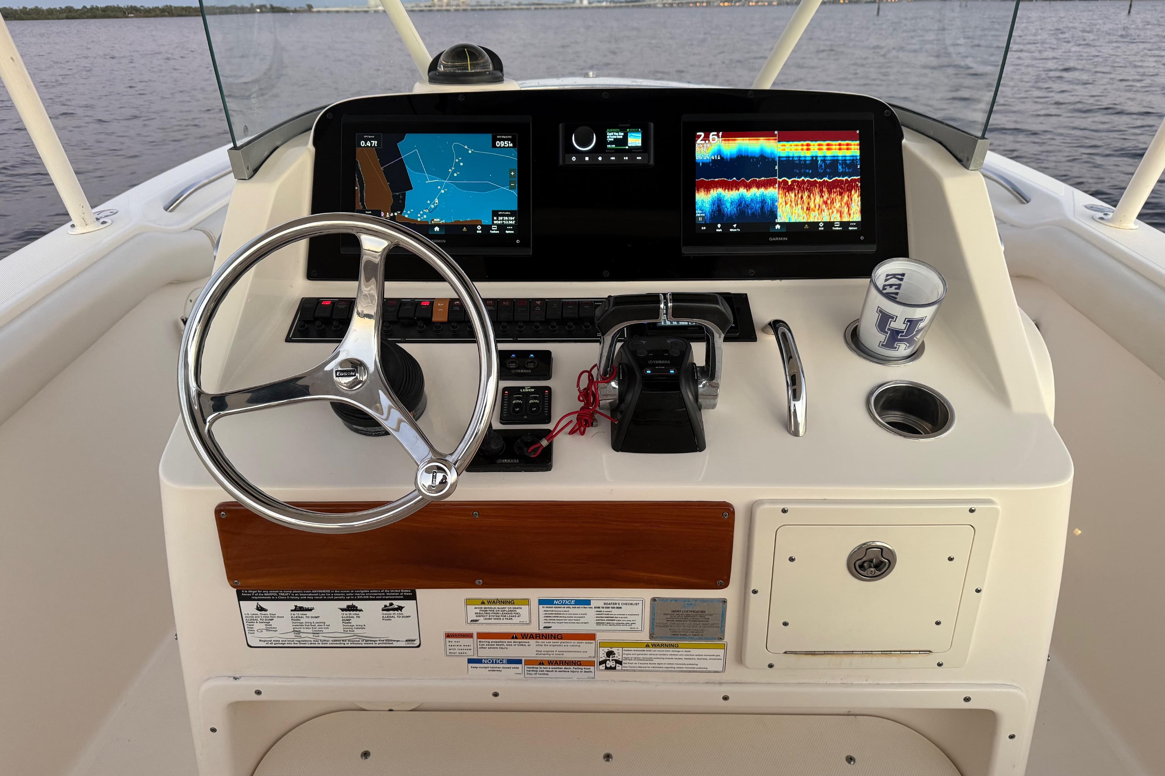 2014 Pursuit S 280 Sport boat dashboard with navigation screens and steering wheel.