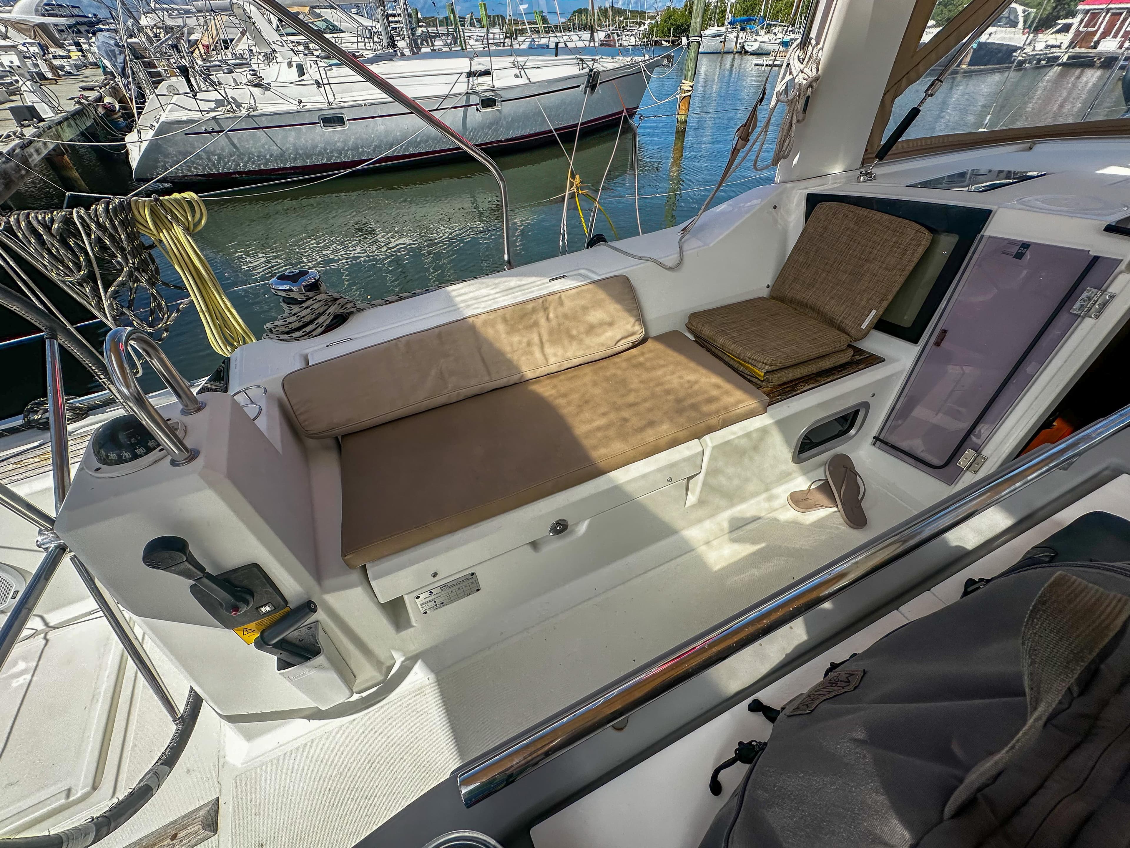 2018 Beneteau Oceanis 41.1 yacht cockpit with cushioned seating and marina view.