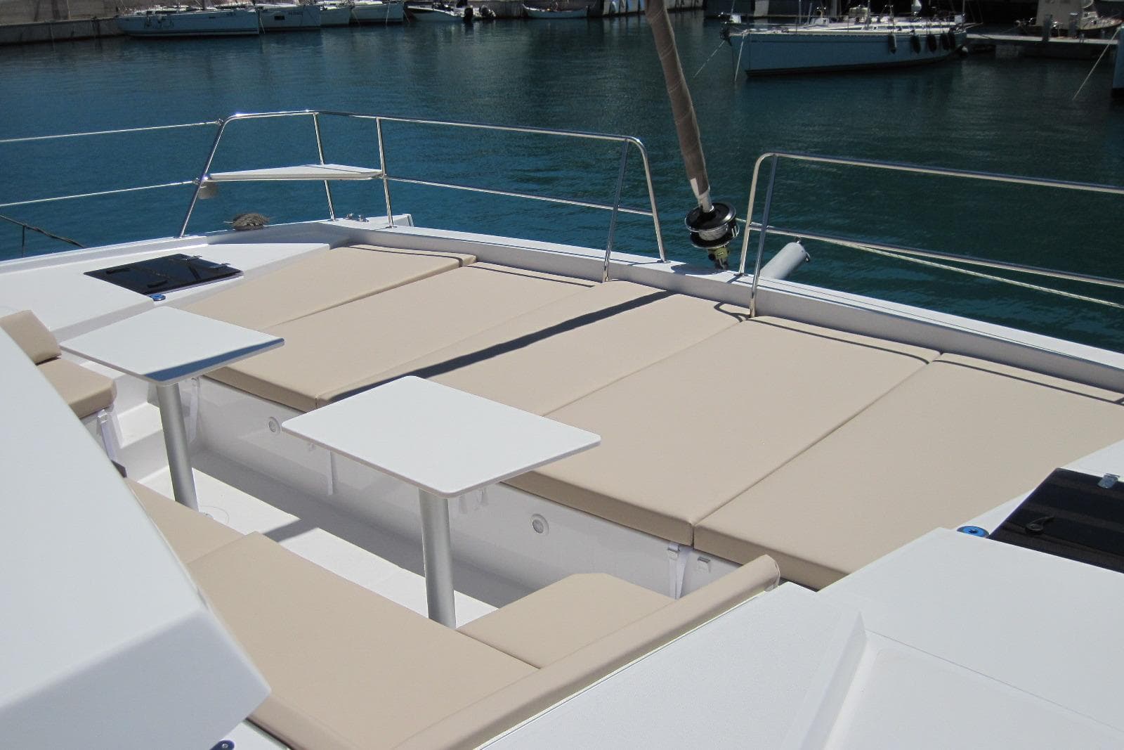 Luxurious 2020 Bali 4.3 catamaran deck with sun loungers and tables, docked in marina.