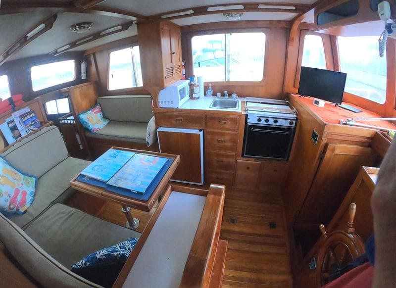 Interior of a 1977 CHB 34 boat with kitchen, seating area, and navigation station.
