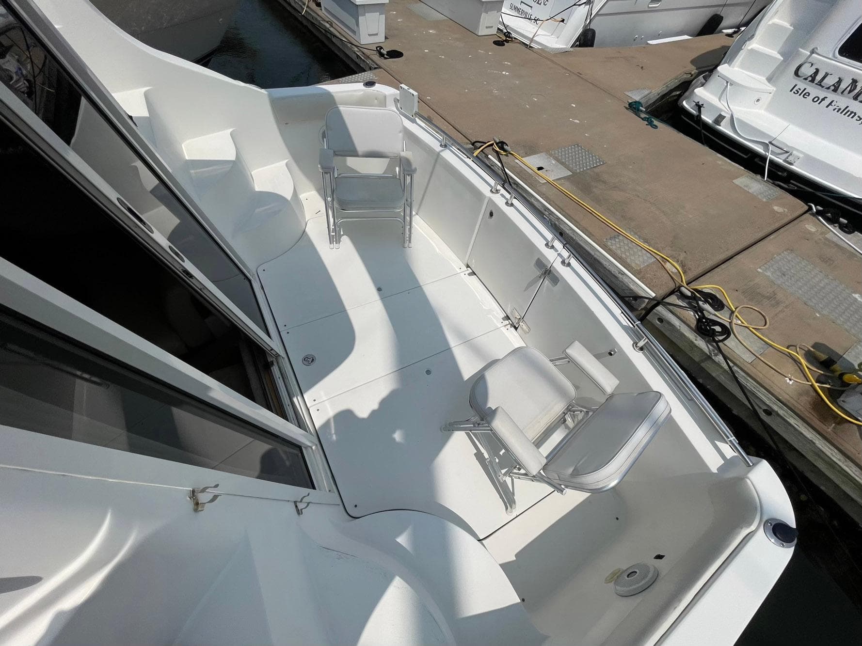 2006 Carver 36 Mariner boat deck with chairs, docked at marina.