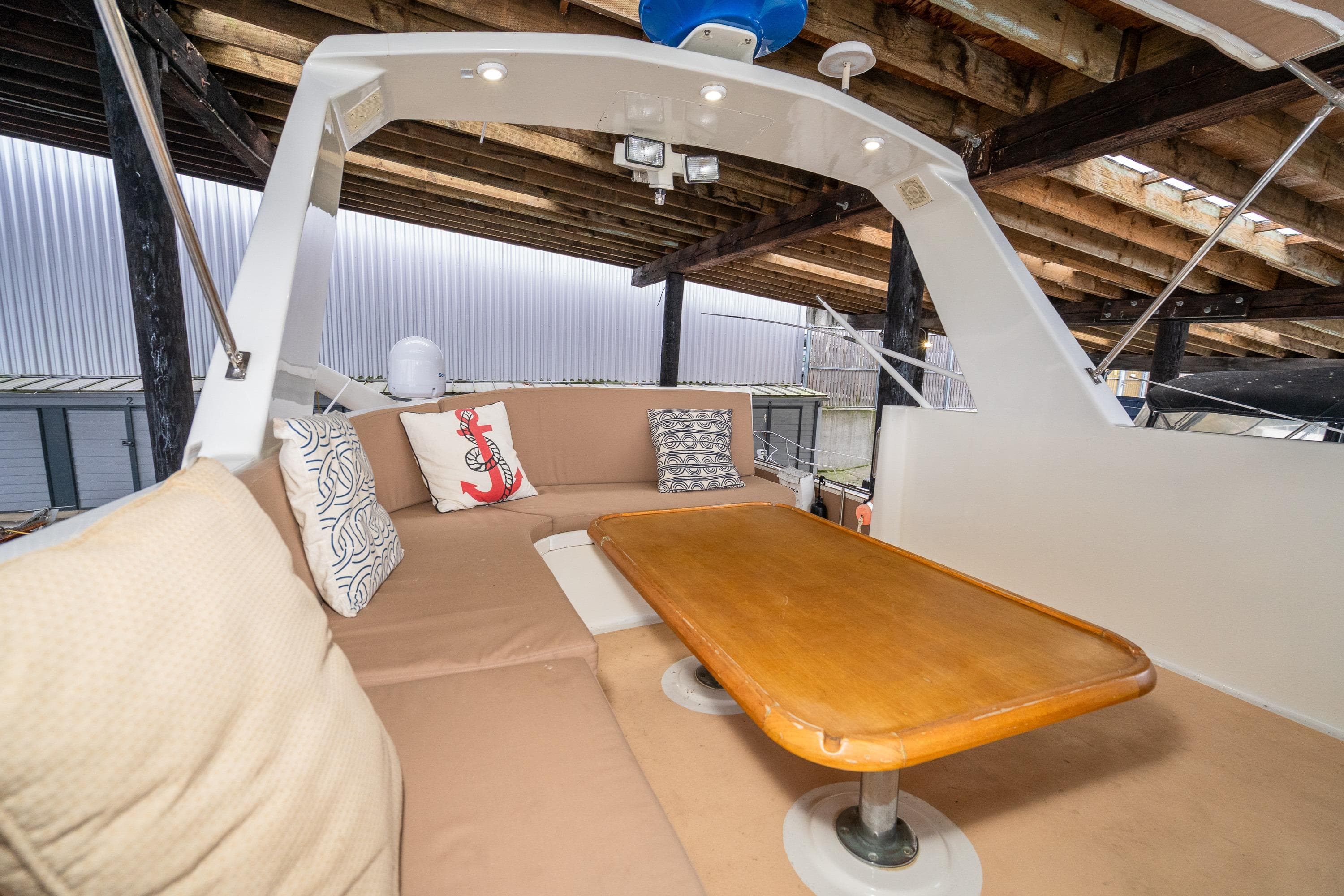 1973 American Marine Alaskan 53 yacht interior with cushioned seating and wooden table.