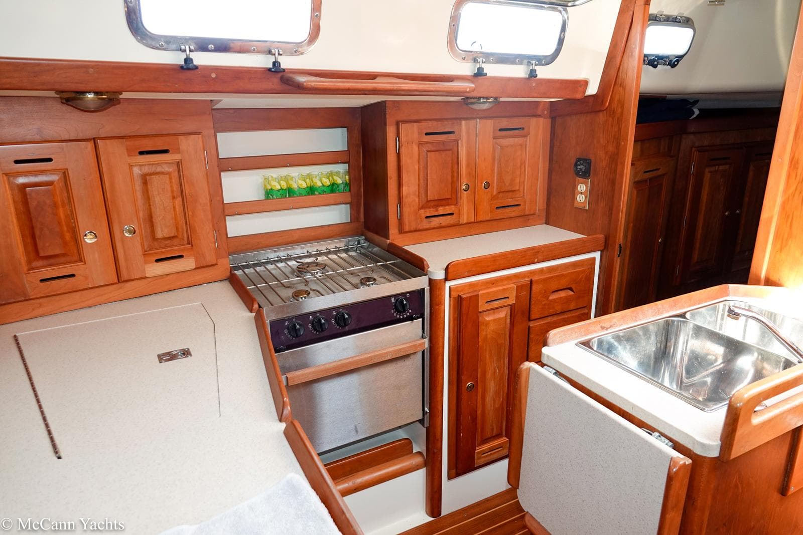 Interior of 2002 Tartan 3700 yacht with wooden cabinetry and compact kitchen area.