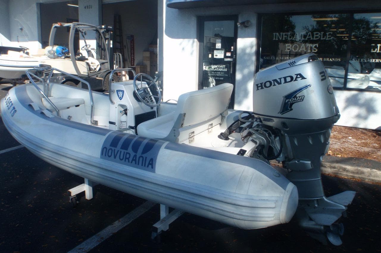 2007 Novurania Deluxe 335 inflatable boat with Honda outboard motor, parked outside a dealership.