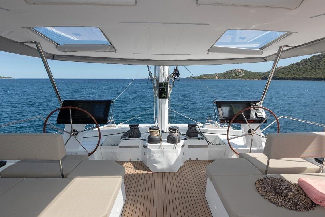 2024 Fountaine Pajot Alegria 67 Catamaran helm with dual steering wheels and ocean view.