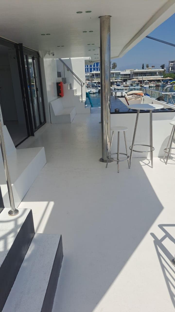 Modern 2015 Power Catamaran deck with seating, bar stools, and marina view.