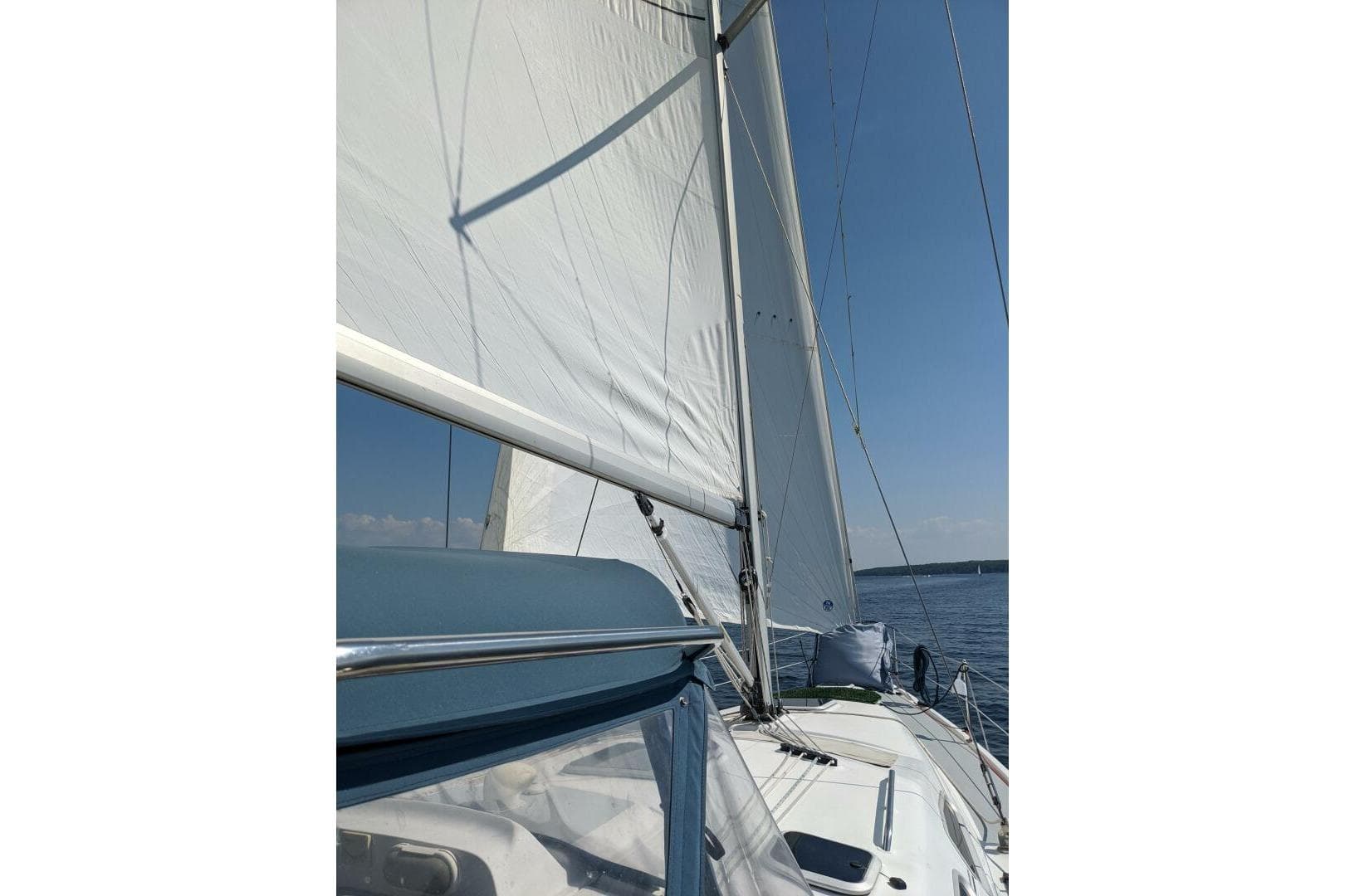 Sailing on a 2004 Hunter 41 AC yacht with white sails against a clear blue sky.