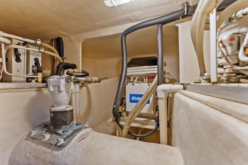 Engine room of 2000 West Bay 58 Sonship yacht, showcasing mechanical components and piping.