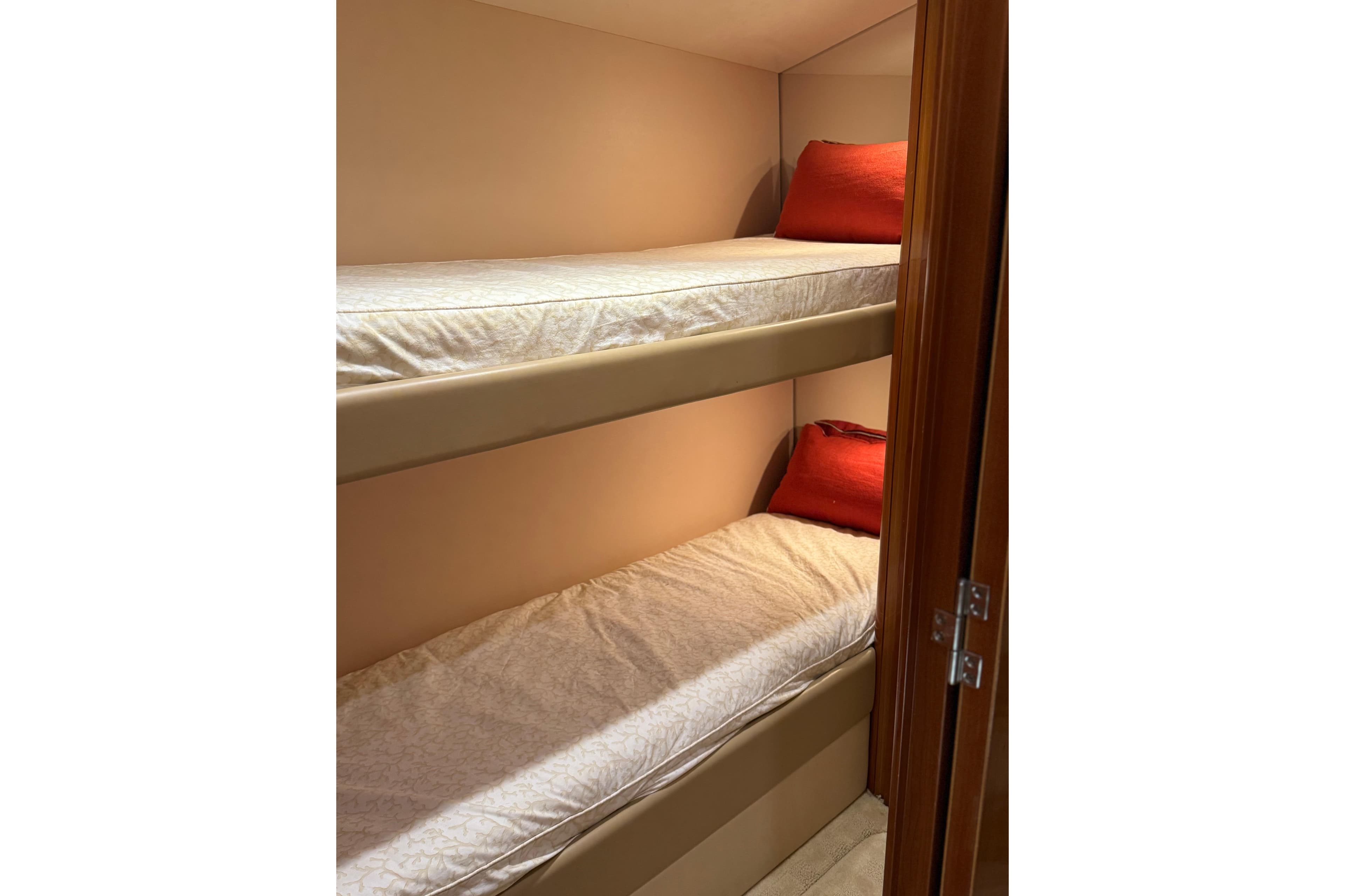 Bunk beds with red pillows in 2004 Hatteras 60 Convertible yacht cabin.