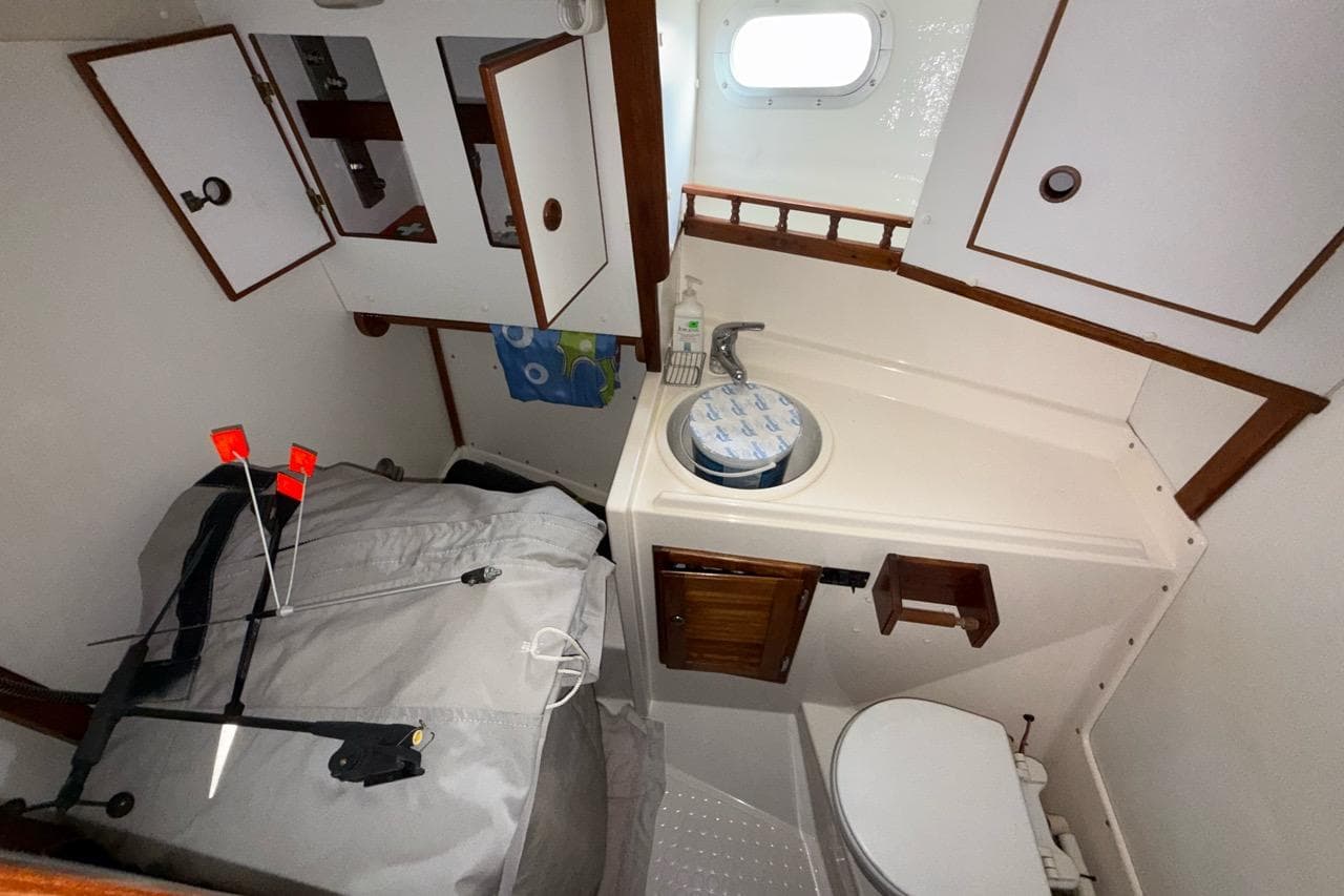 1994 Trident Warrior boat interior with compact bathroom and storage cabinets.