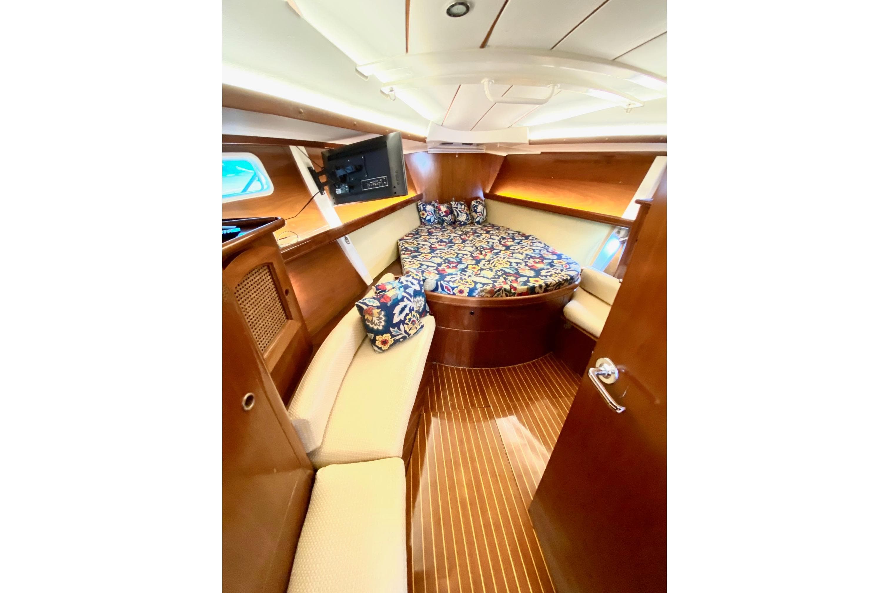 Luxurious cabin interior of 1997 Beneteau Oceanis 461 sailboat with wood finish and cozy bedding.