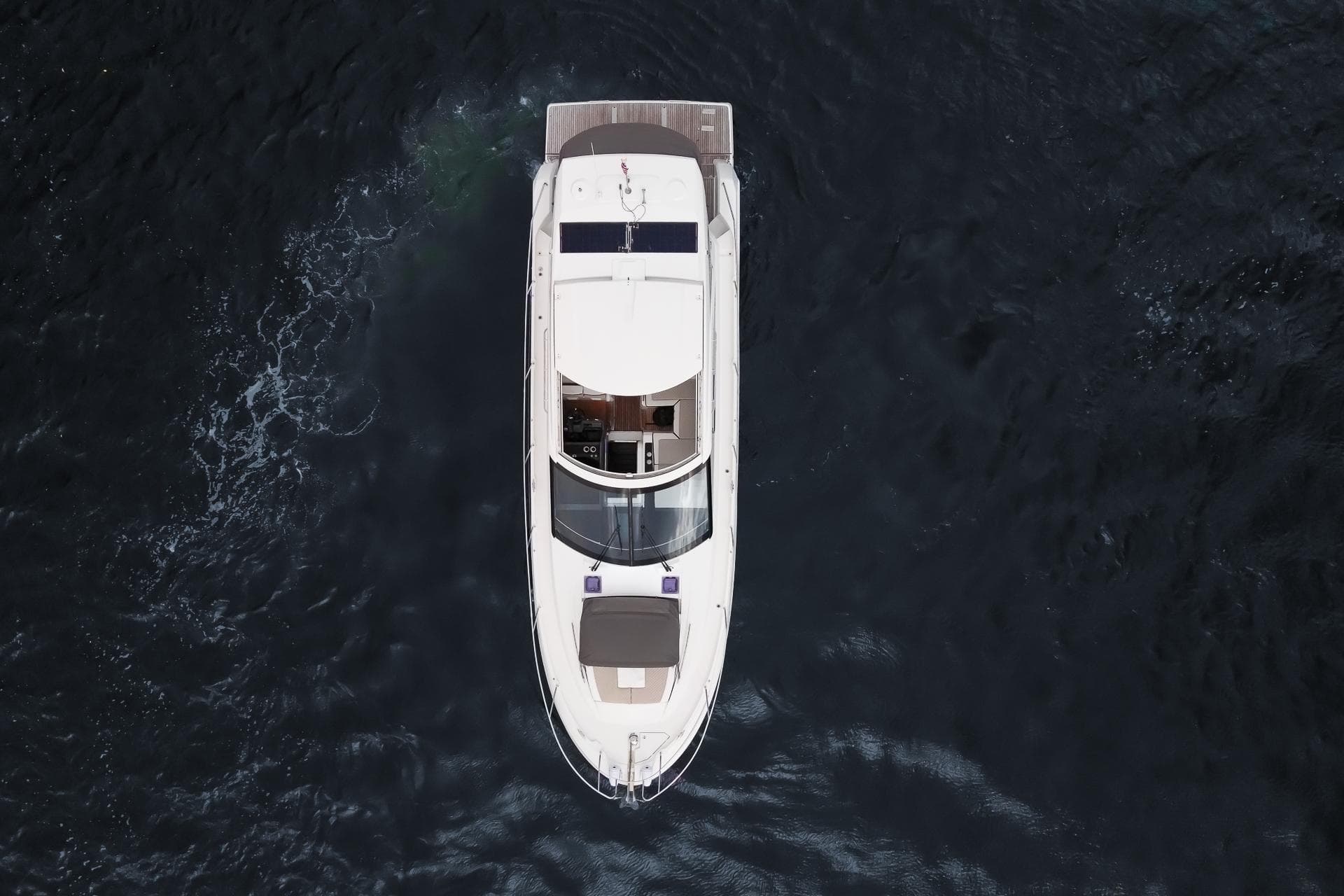 Overhead view of 2018 Jeanneau Leader 46 yacht cruising on dark water.