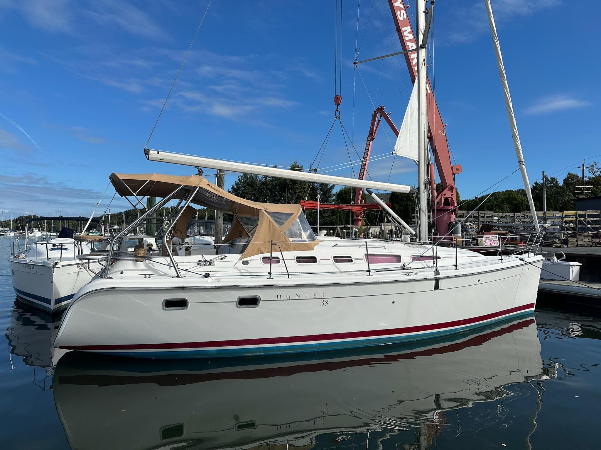 2005 Hunter 38 sailboat docked in a marina under a clear blue sky.