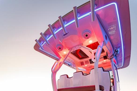 2018 Scout 355 LXF boat with illuminated helm and seating area at sunset.