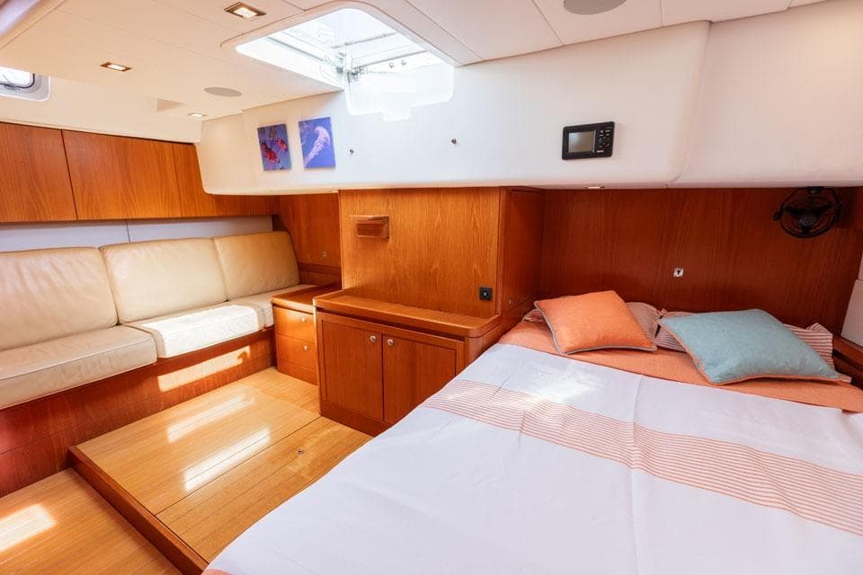Luxurious interior of 2008 Nautor Swan 66 yacht with cozy bed and seating area.