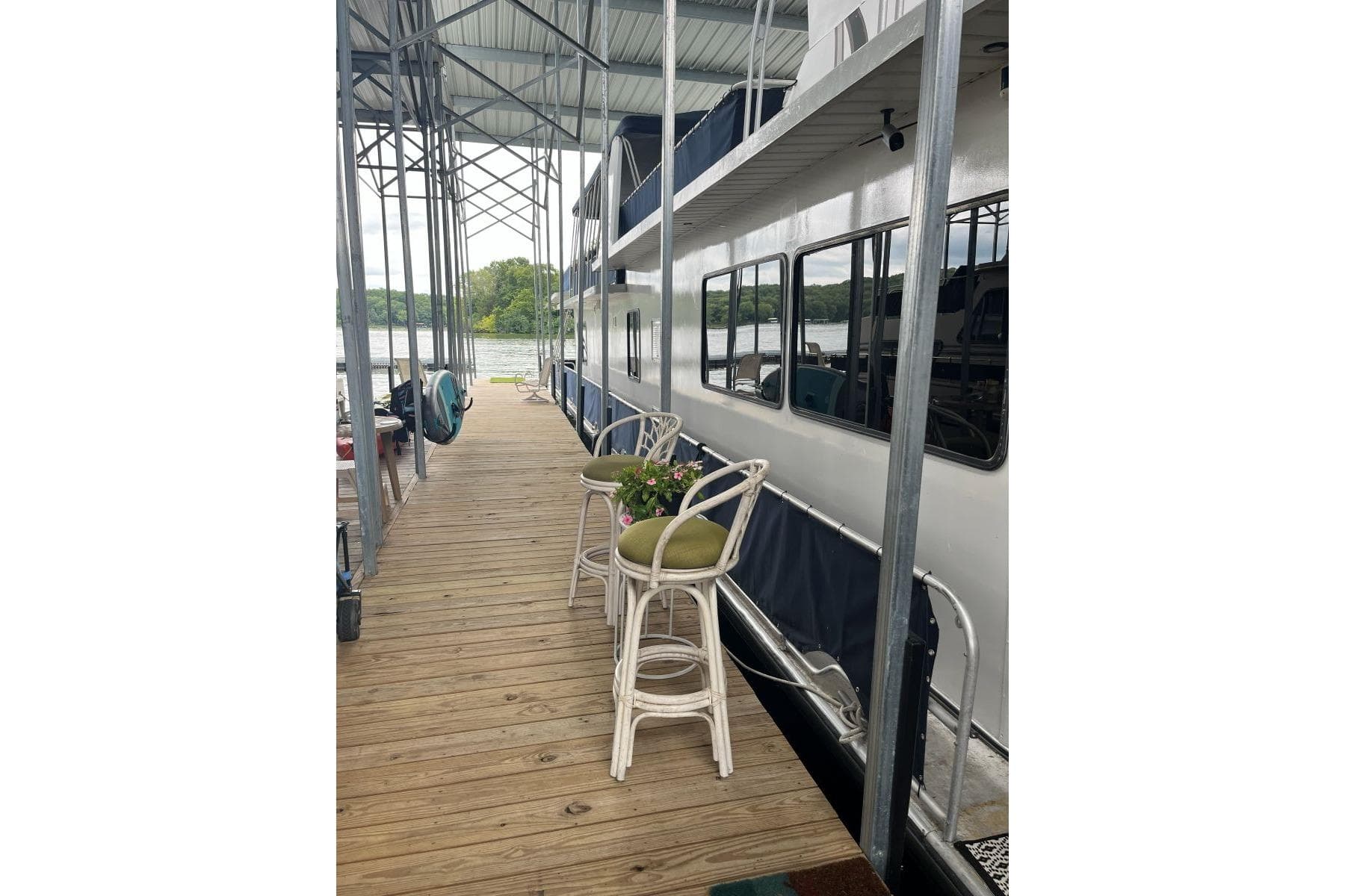 1985 Sumerset 18x81 houseboat docked with outdoor seating and scenic lake view.