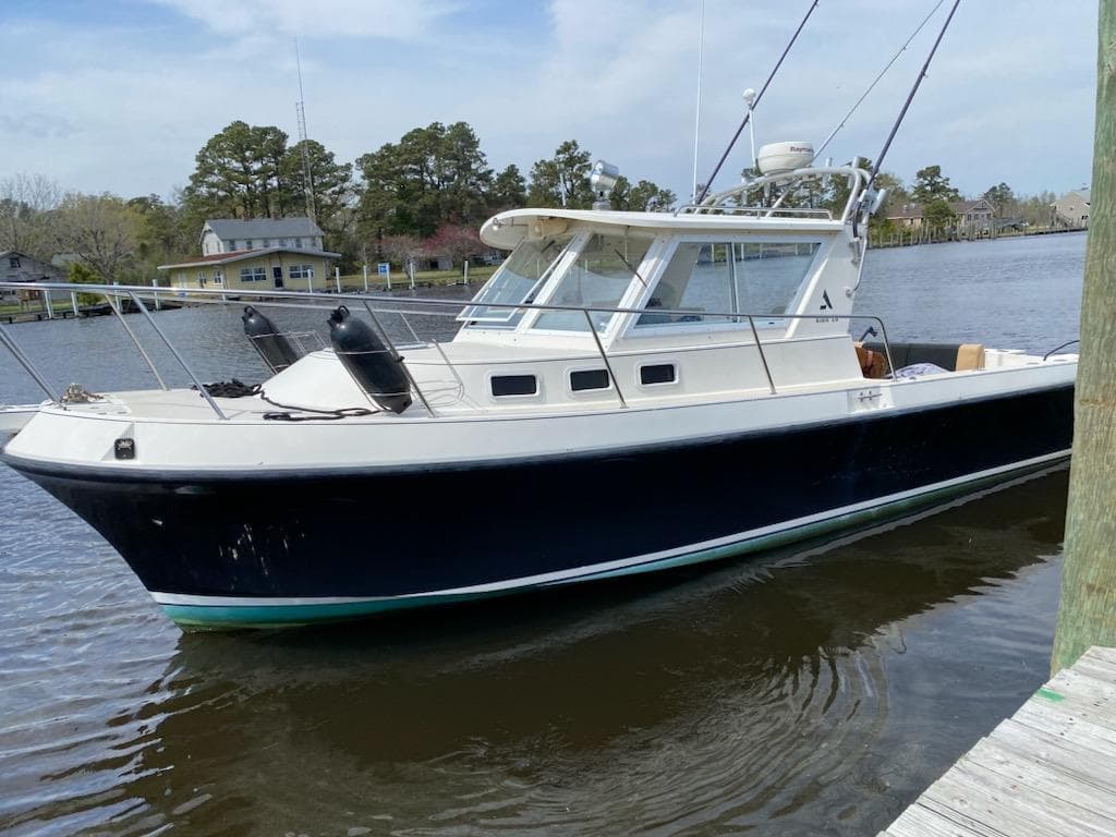 1995 Albin 28 Tournament Express boat docked on a calm river.