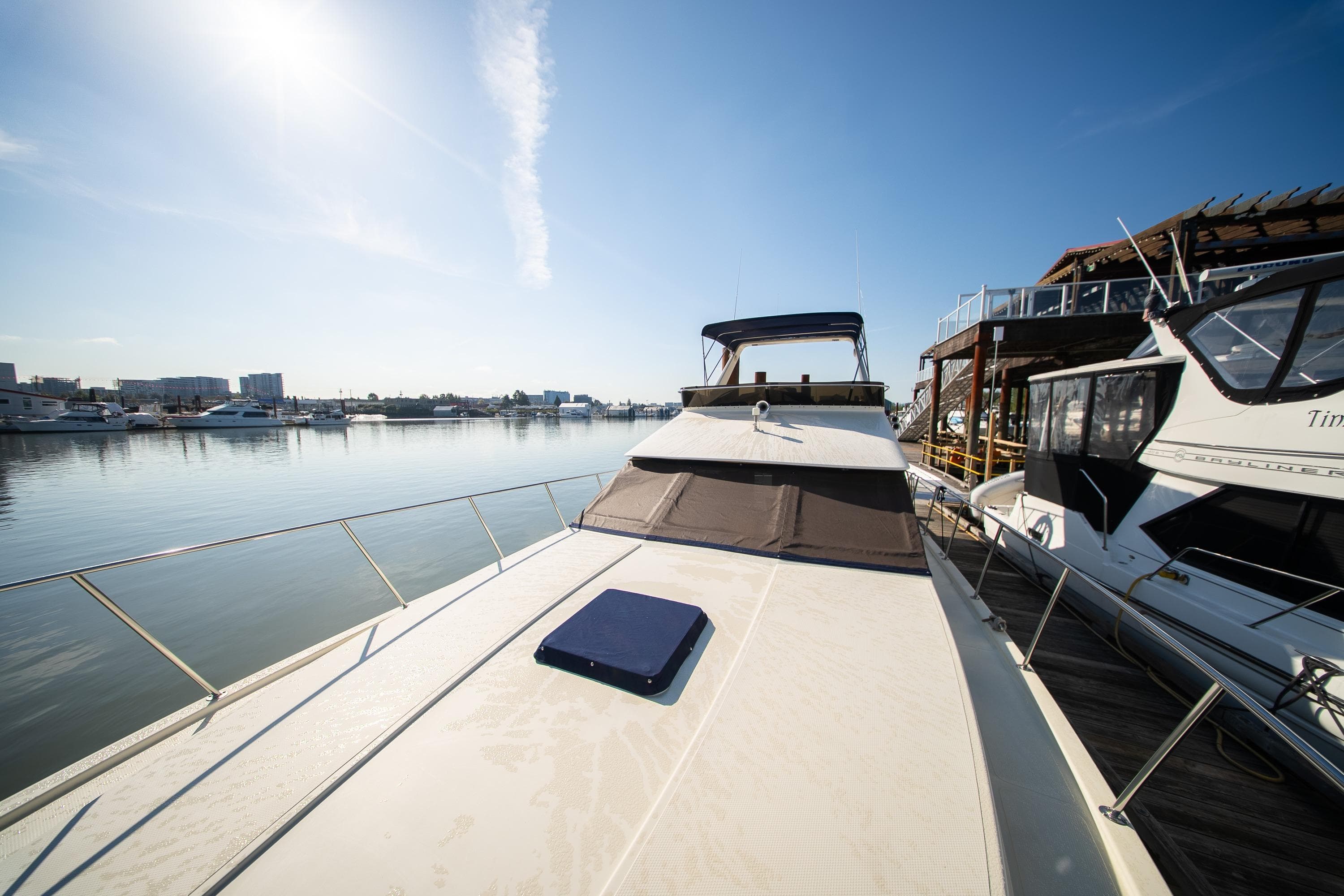 1990 Tollycraft 44 Sedan yacht docked in a sunny marina, showcasing sleek design.