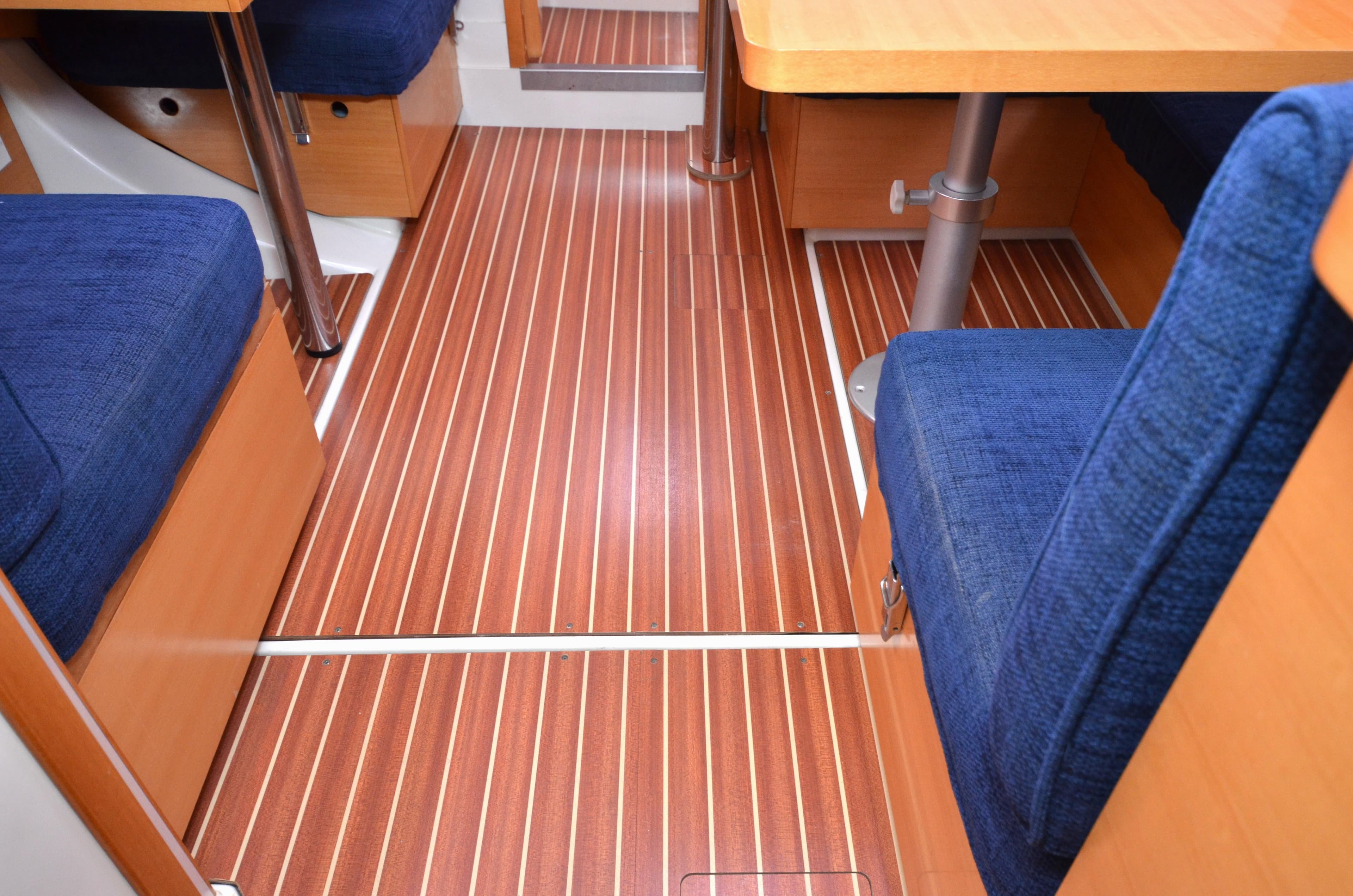 Interior of 2007 Hanse 370e yacht with wooden flooring and blue seating.