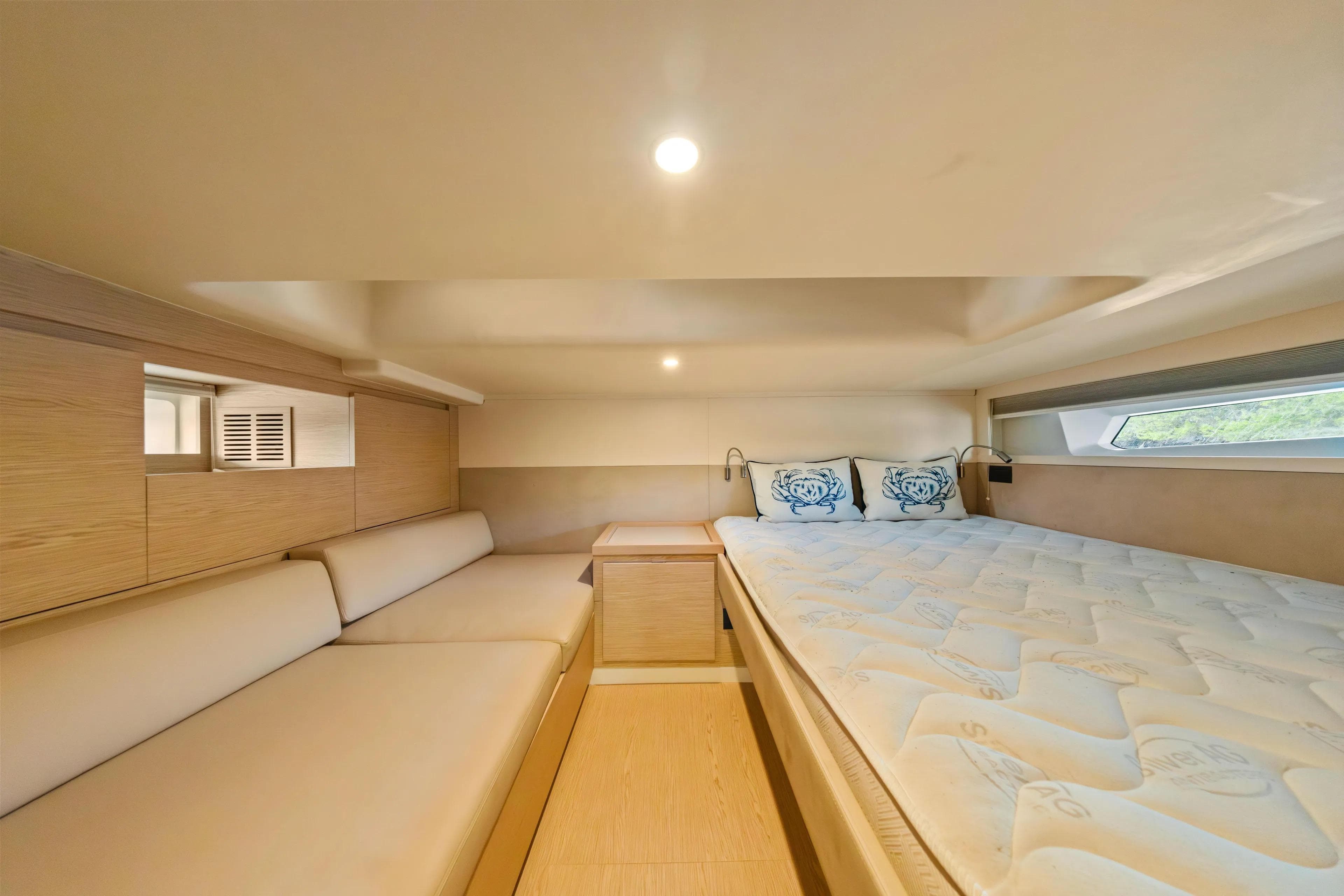 Luxurious interior cabin of 2024 Solaris Power 44 Open yacht, featuring cozy bed and seating.